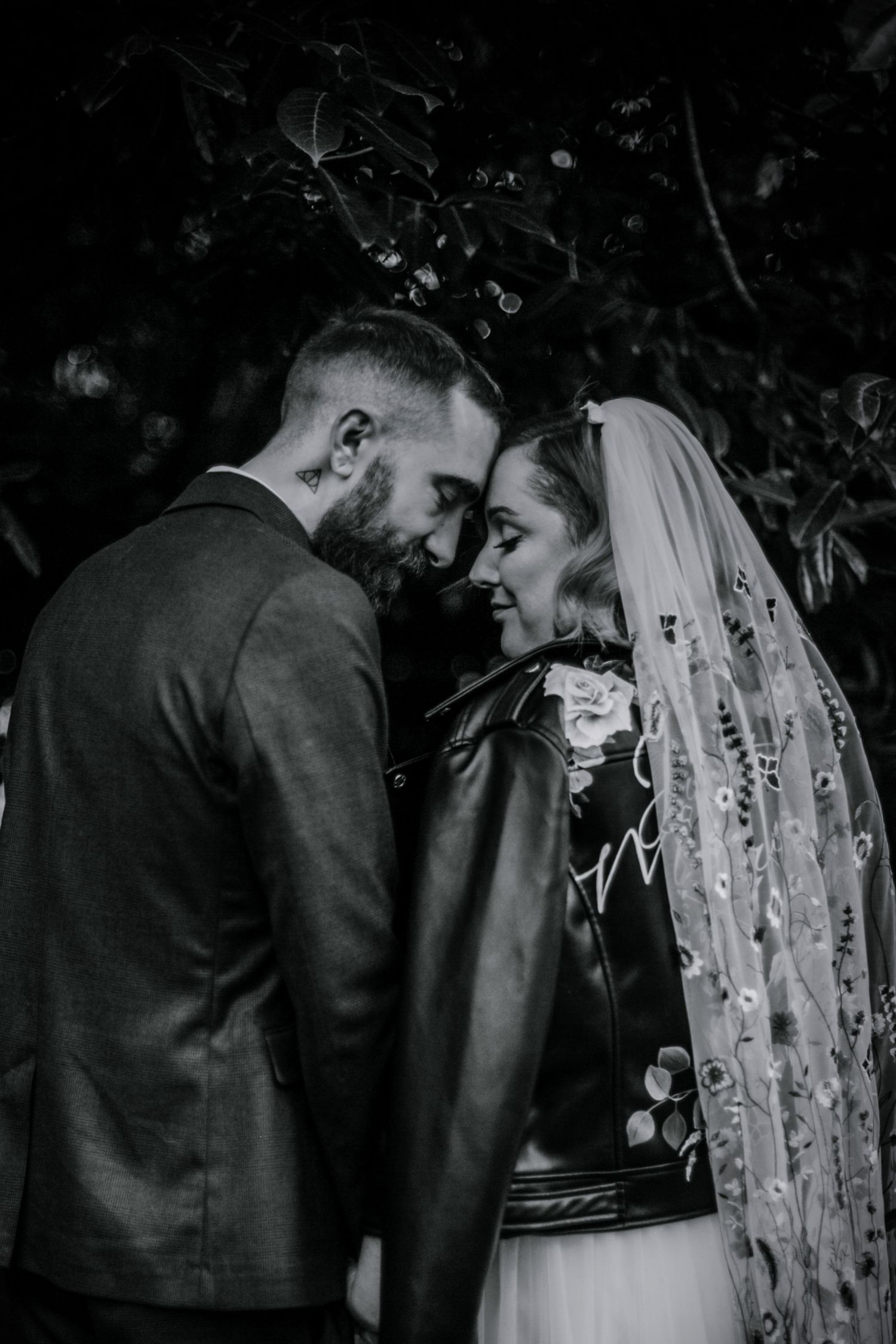 A joyful embrace – The bride and groom lean in for a forehead embrace, both eyes closed