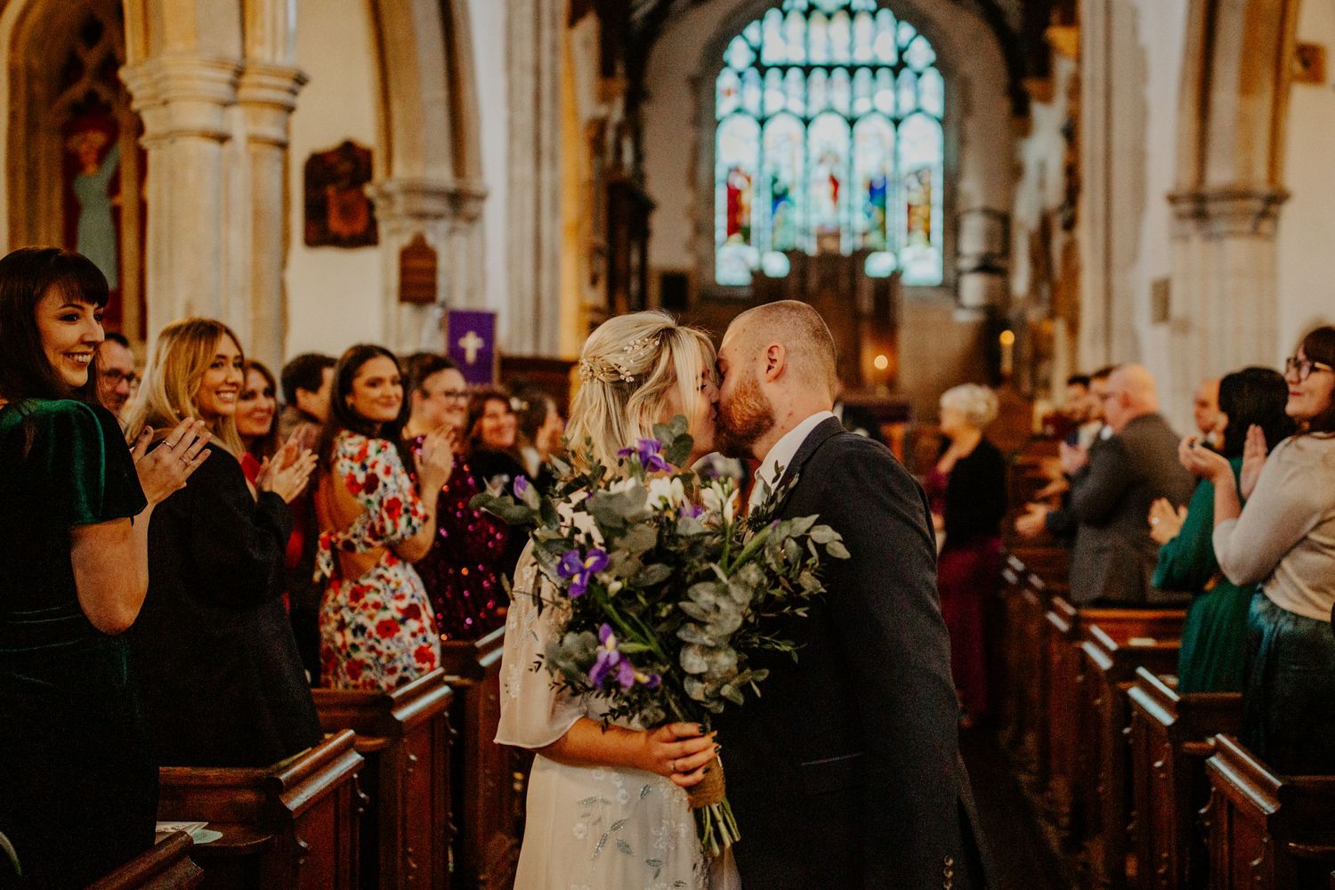 Birde and groom kissing at end of isle at Braughing Church Hertfordshire, Photographer RELM Photography