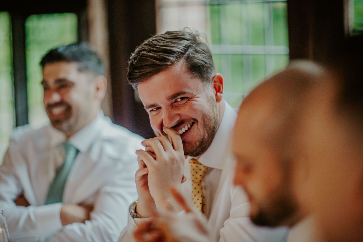 Wedding guest laughing at Ramster Hall, Chiddingfold, Godalming.