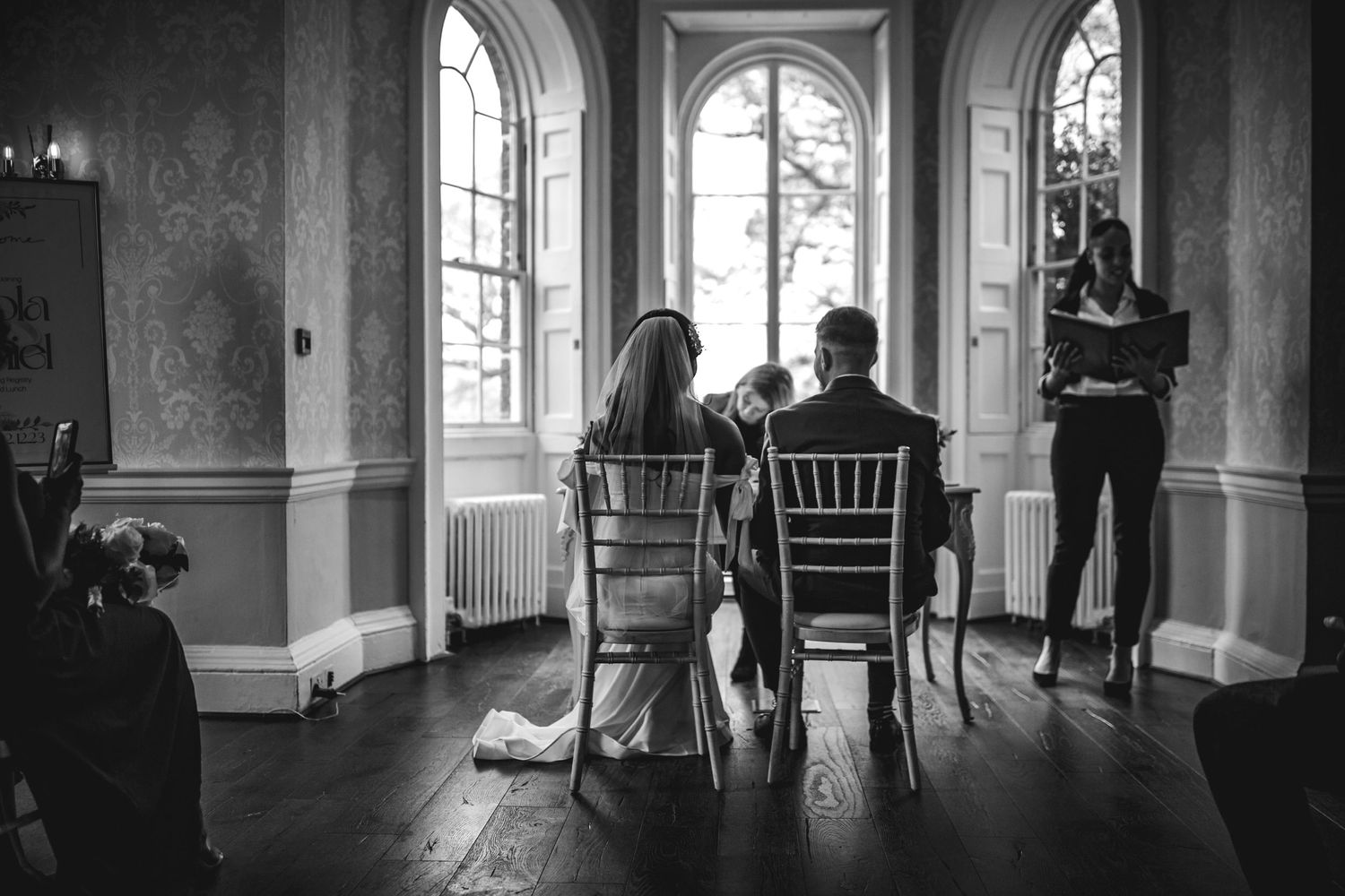Bride and Groom sitting on chairs at their wedding ceremony at Morden Park House - London - RELM Photography