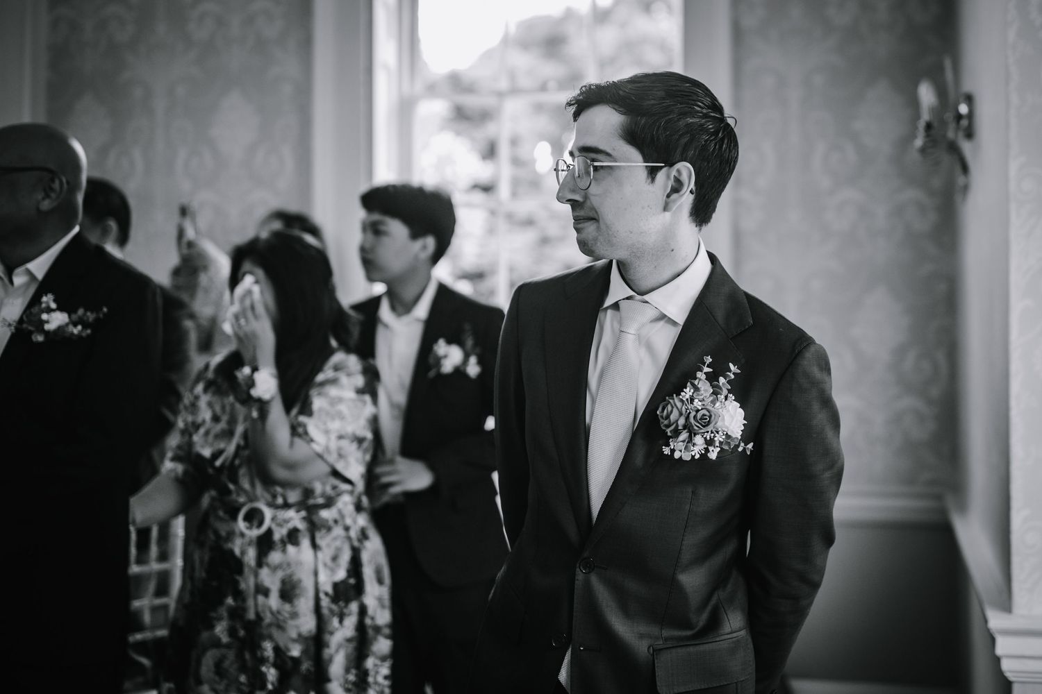 Groom smiles as he sees his bride arriving for the ceremony at Morden Park.