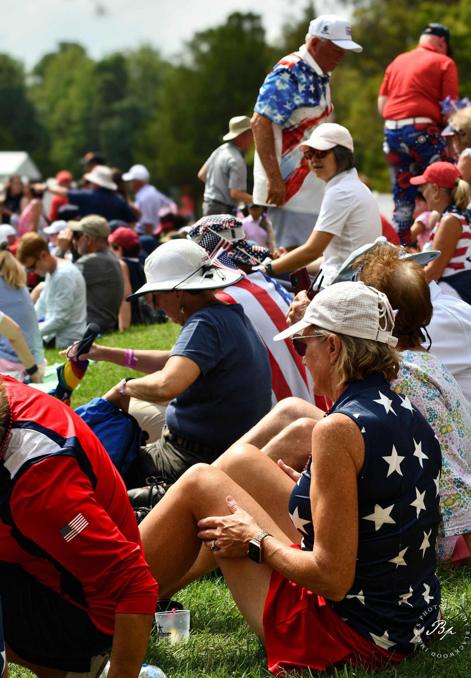 Patriotic American fans in red white and blue outfits watching Solheim Cup golf.