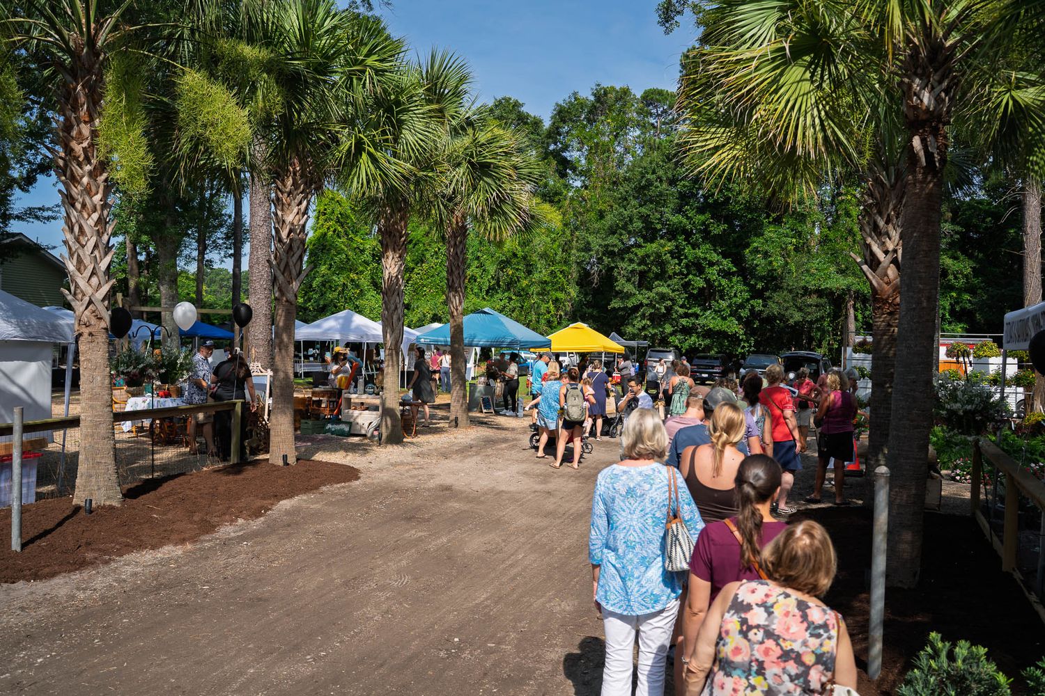 Visitors explore vendor booths and shaded walkways during the Bluffton Farm and Flea grand opening in Bluffton, South Carolina.