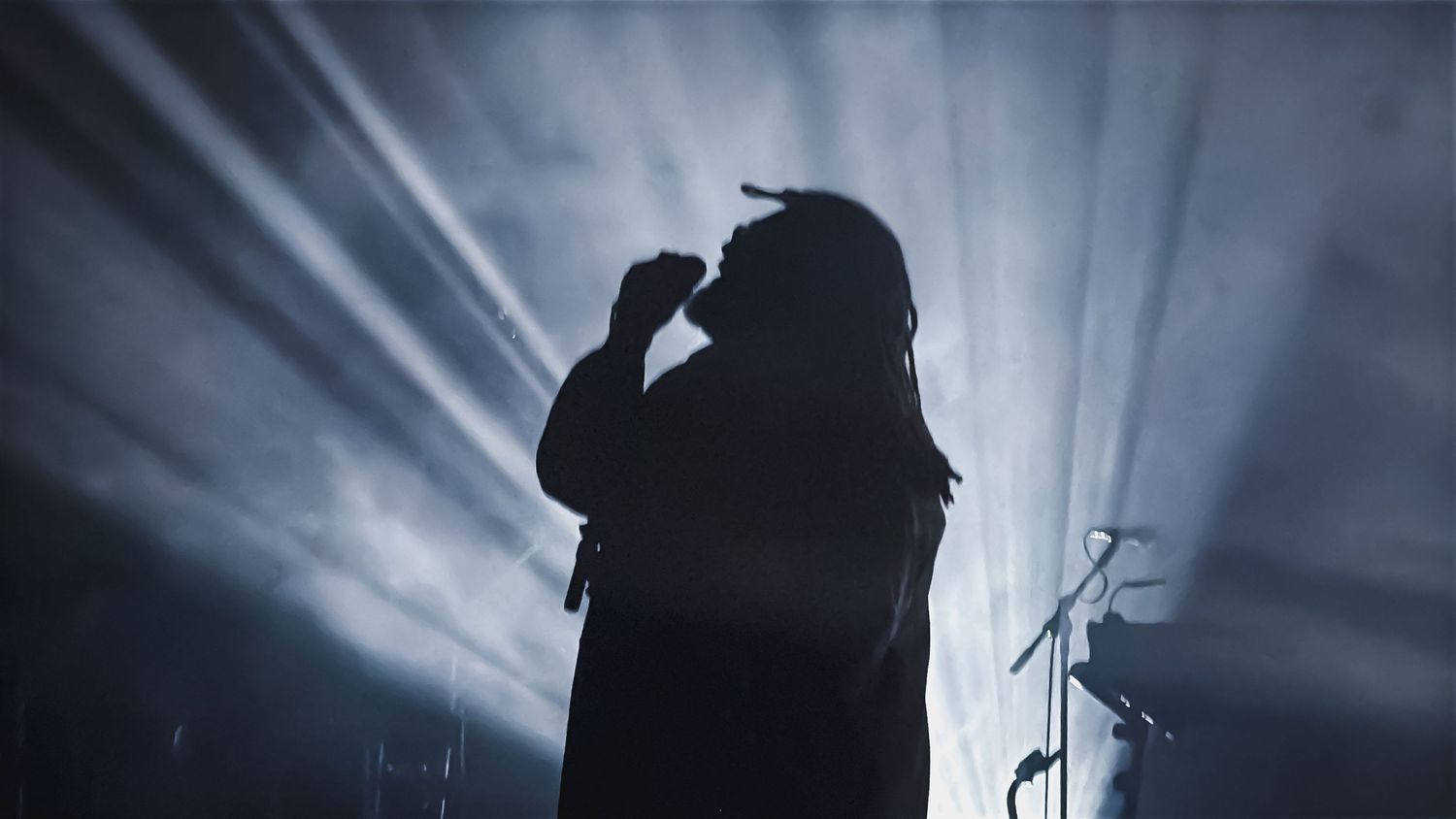 Elmiene performs live in Charleston under dramatic blue stage lighting during an intimate concert captured on an iPhone.