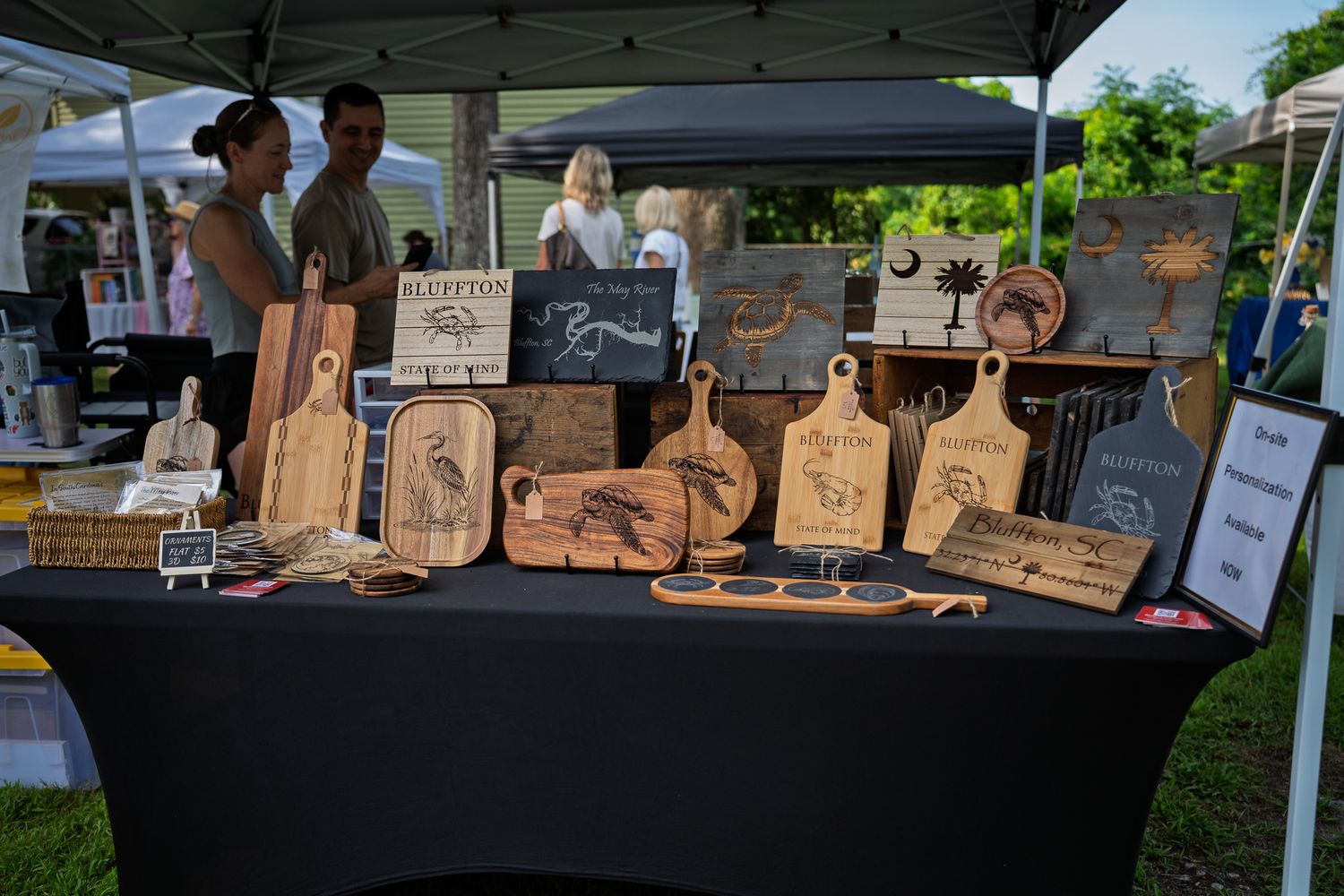Locally crafted wooden cutting boards, serving trays, and Bluffton themed gifts displayed at Bluffton Farm and Flea.