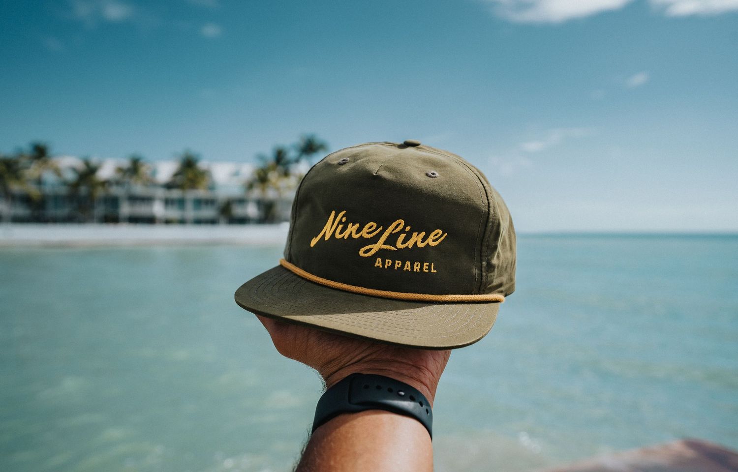 Lifestyle product photography featuring a Nine Line Apparel hat photographed outdoors near the coast by GoodnRich Photography