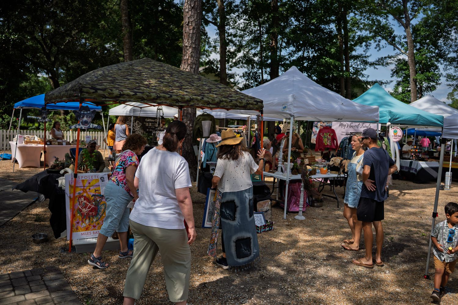 Shoppers browse handcrafted goods and artisan products during the Bluffton Farm and Flea grand opening in Bluffton, South Carolina.