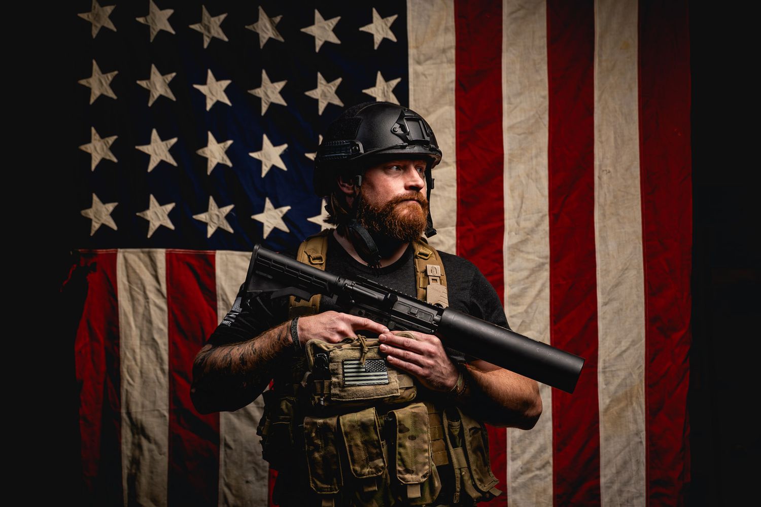 Veteran preparing to fire confetti conceptually from the Can Cannon while standing before a large American flag.