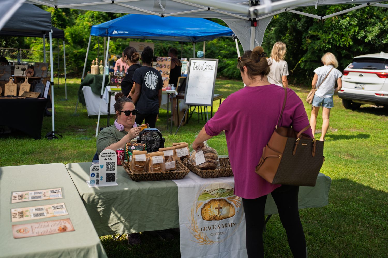 A customer shops for fresh sourdough bread at the Grace & Grain vendor booth during Bluffton Farm and Flea in Bluffton, South Carolina.
