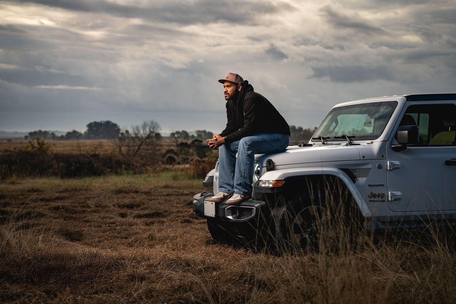Outdoor lifestyle portrait in the South Carolina Lowcountry featuring a man sitting on a Jeep during golden hour by GoodnRich Photography