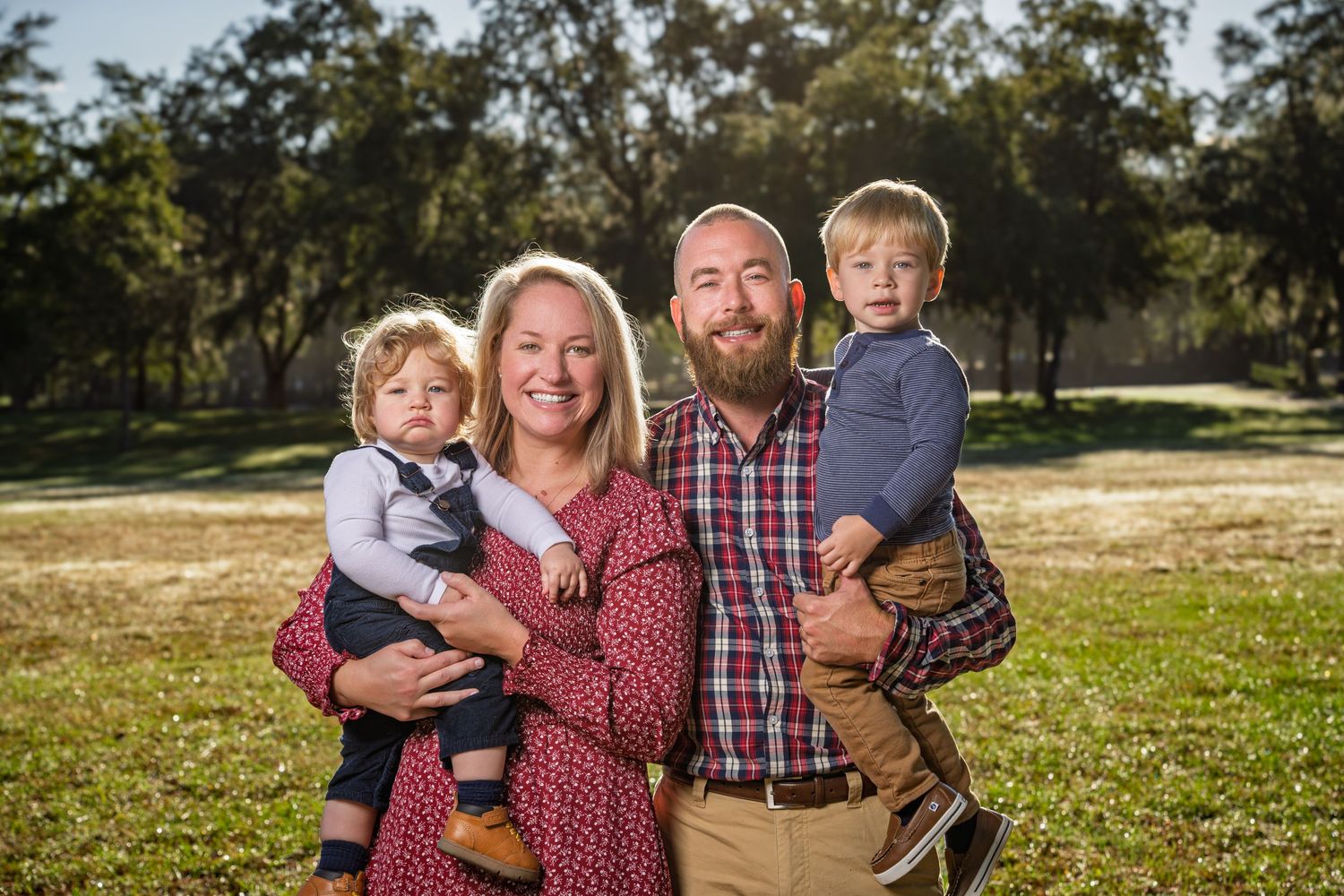 Family lifestyle photography session in Bluffton featuring a family of four captured outdoors during golden hour by GoodnRich Photography