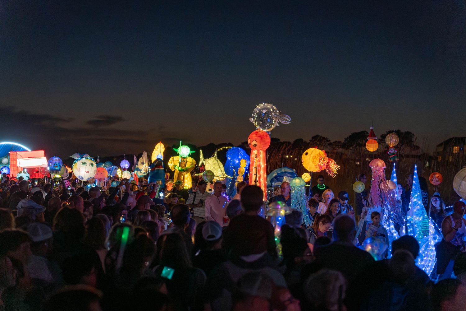 Bright, whimsical sea-creature lanterns light up the beach as families gather during the Hilton Head Island Lantern Parade.