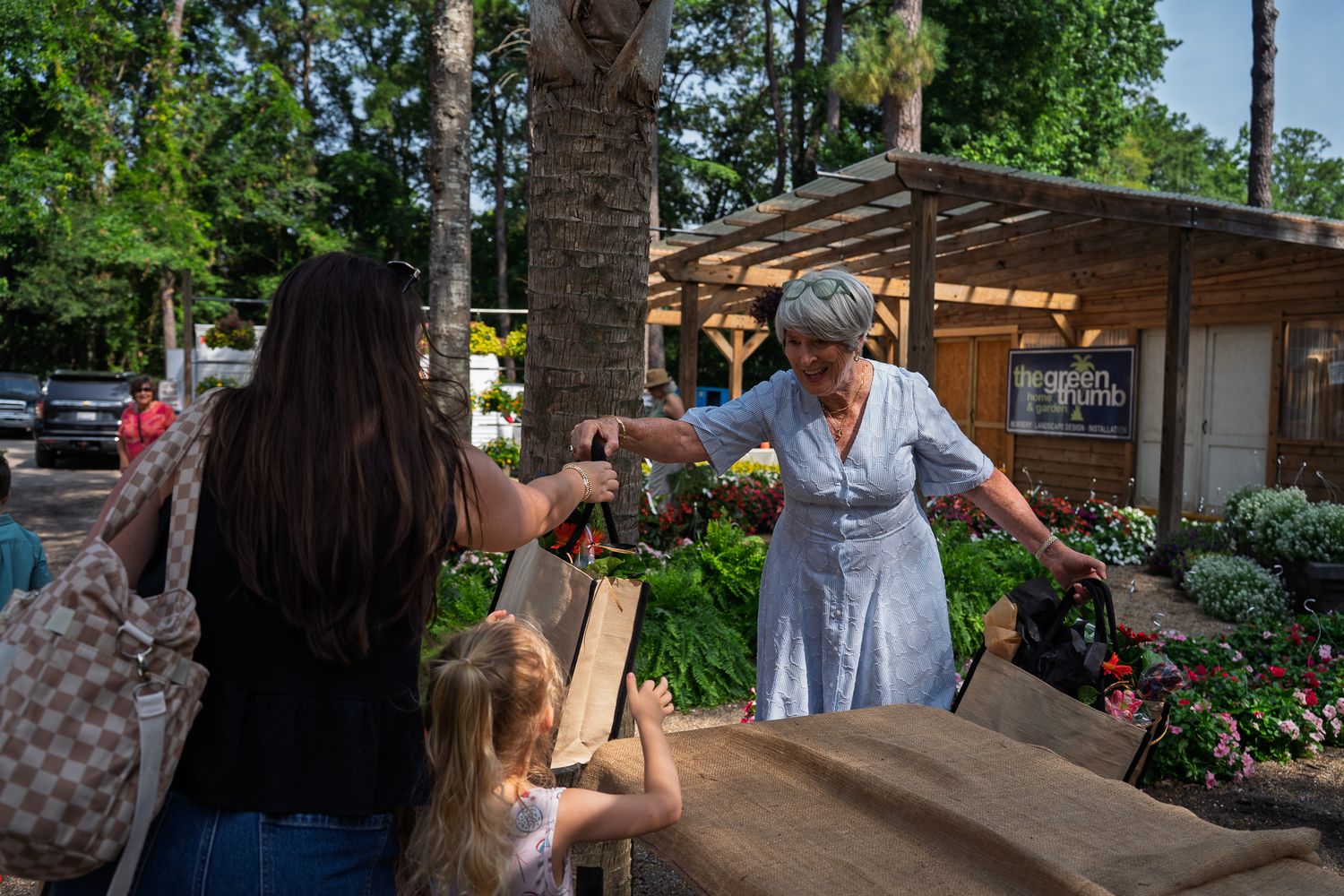 A reusable Bluffton Farm and Flea shopping bag filled with flowers and fresh market purchases on opening day.