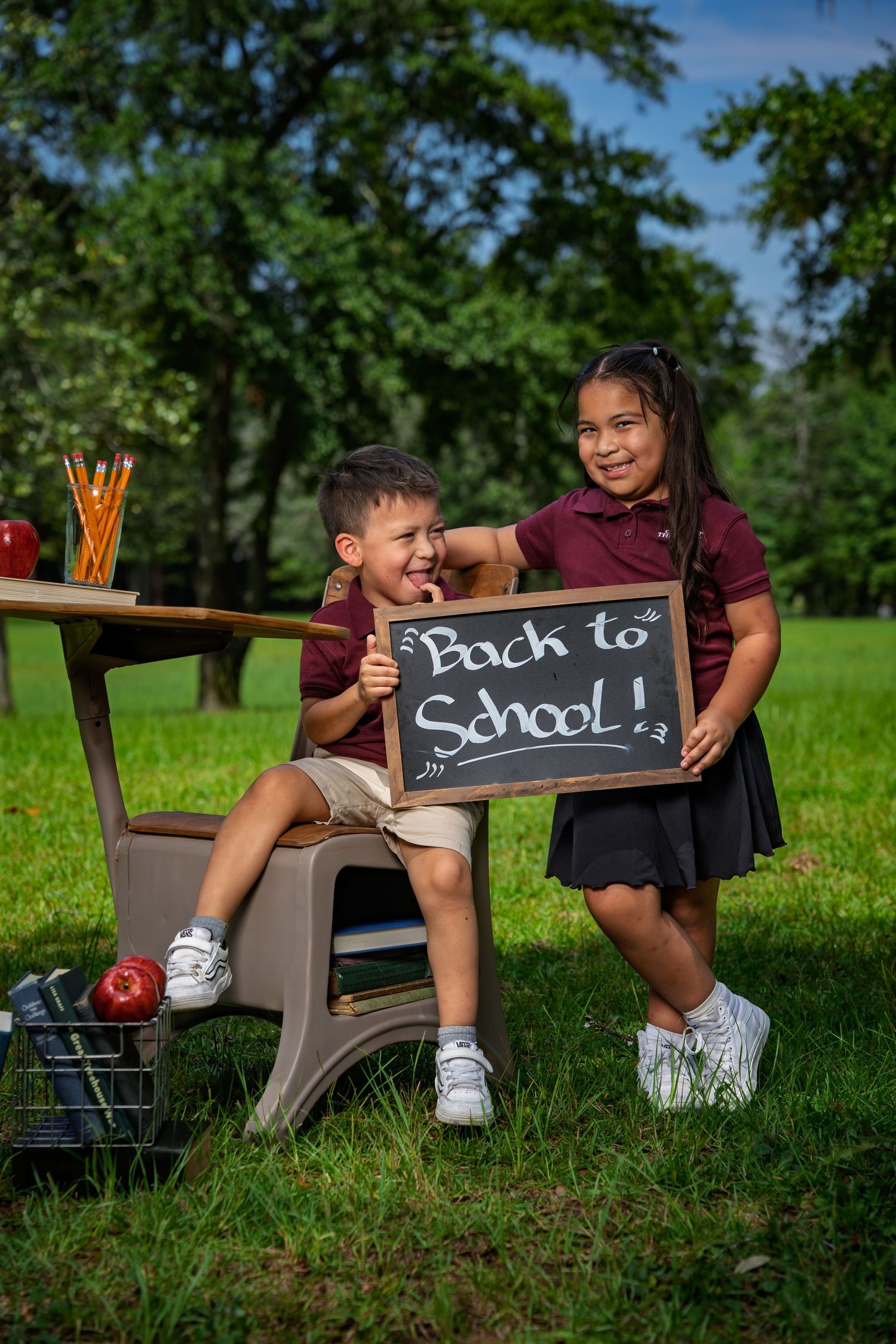 Two children posing with a Back to School sign during a photo session at Red Barn Park at New Riverside in Bluffton, SC.