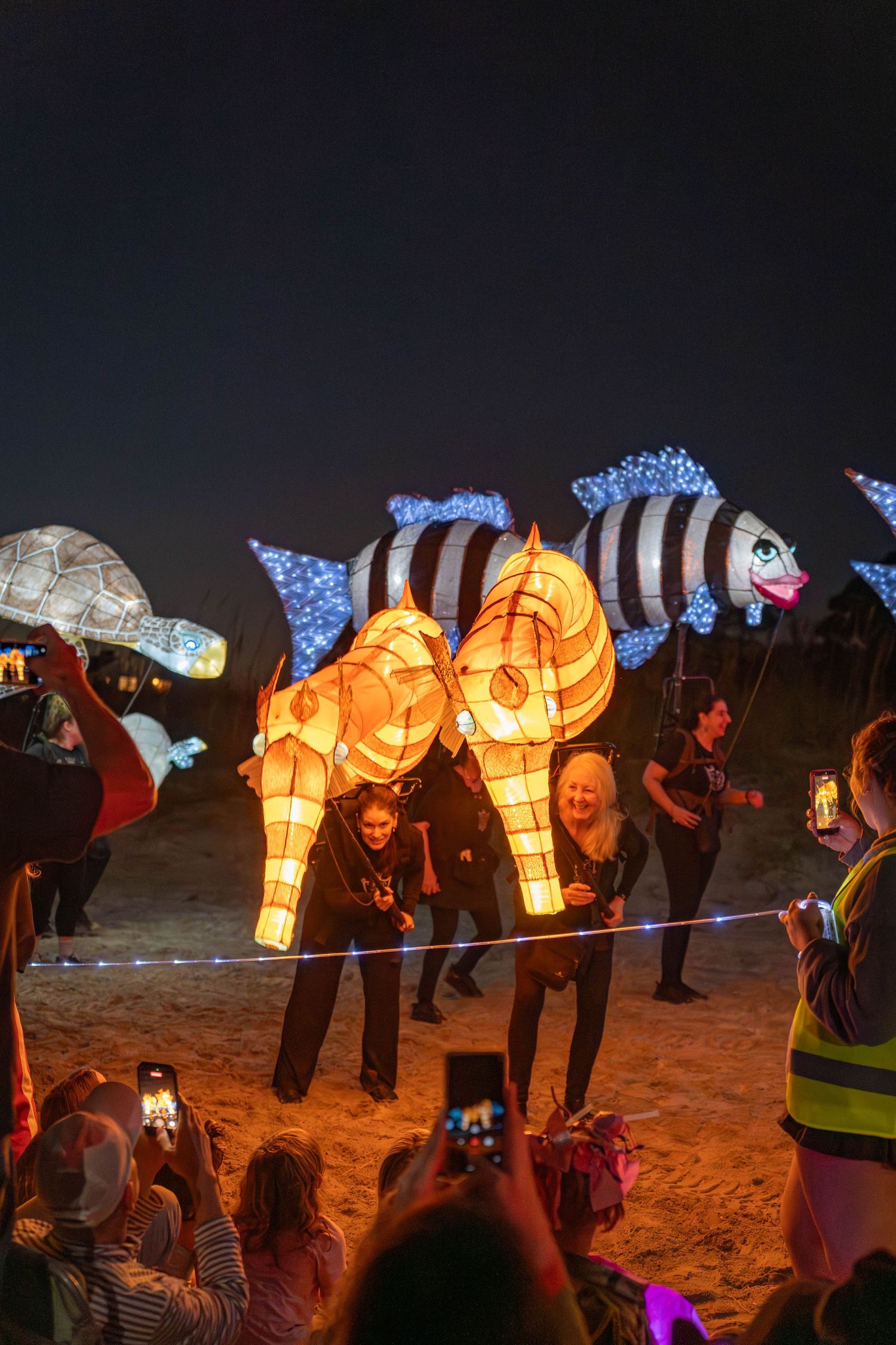 Massive glowing seahorse lantern towering above the crowd at the nighttime Hilton Head Island Lantern Parade.