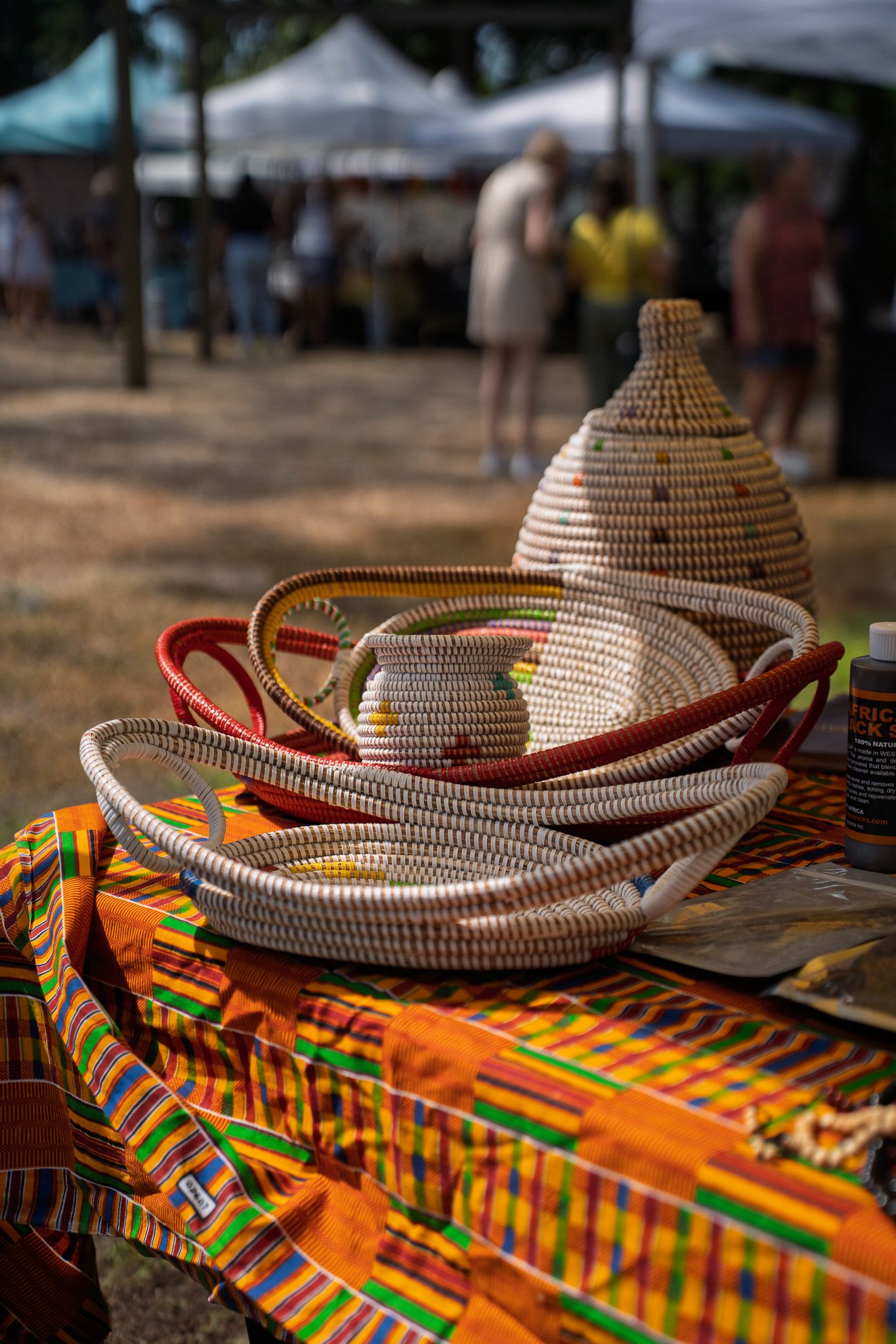Handwoven baskets displayed on a colorful artisan table during the Bluffton Farm and Flea grand opening in Bluffton, South Carolina.