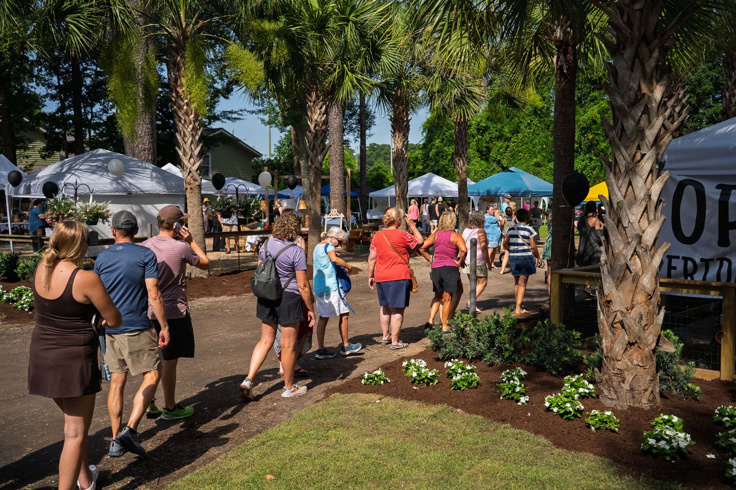 People line the sidewalk outside Bluffton Farm and Flea before entering the grand opening event in Bluffton, South Carolina.