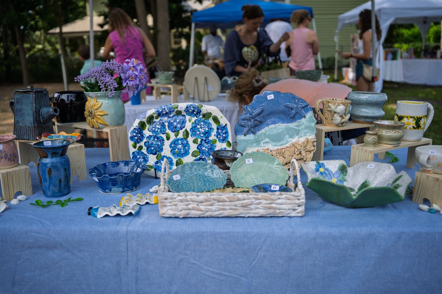 Handcrafted pottery, ceramic bowls, mugs, and coastal themed artwork displayed during the Bluffton Farm and Flea grand opening in Bluffton,