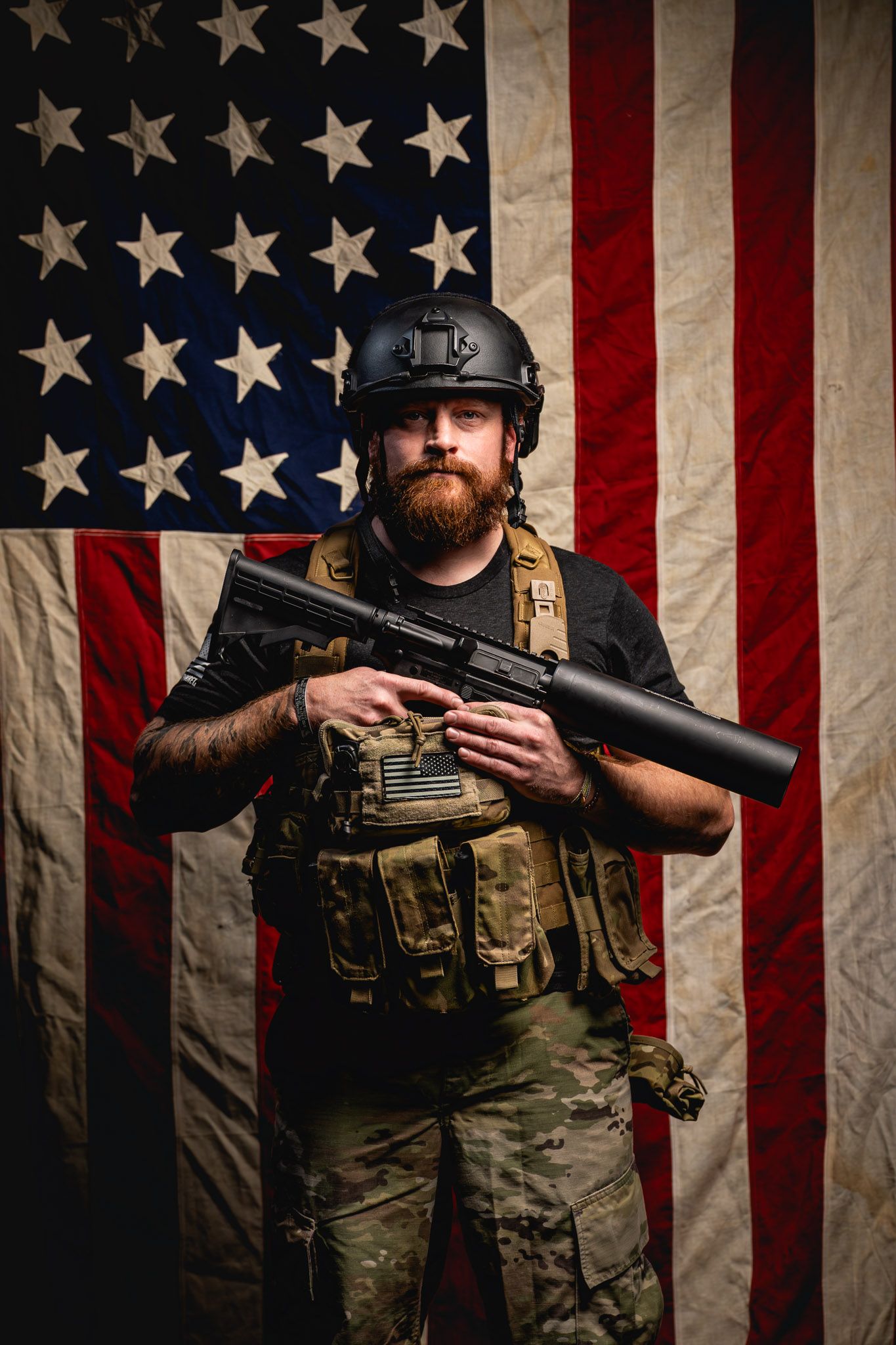 Close-up portrait of veteran in helmet and tactical gear holding the Can Cannon during a patriotic studio photoshoot.