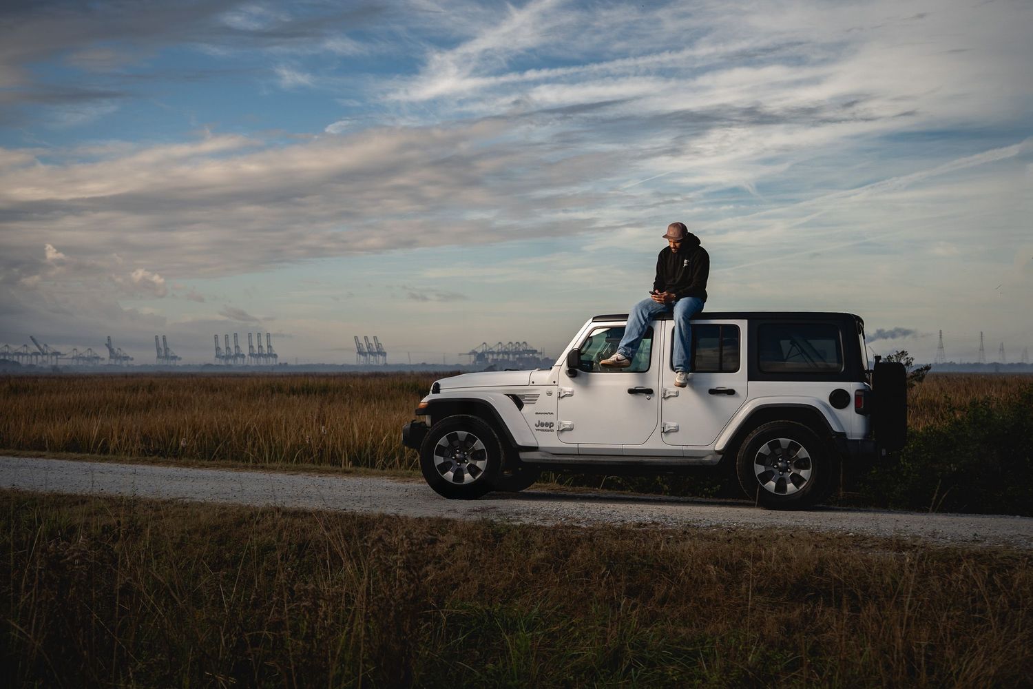 Outdoor lifestyle portrait in the South Carolina Lowcountry featuring a Jeep parked along scenic marshland by GoodnRich Photography