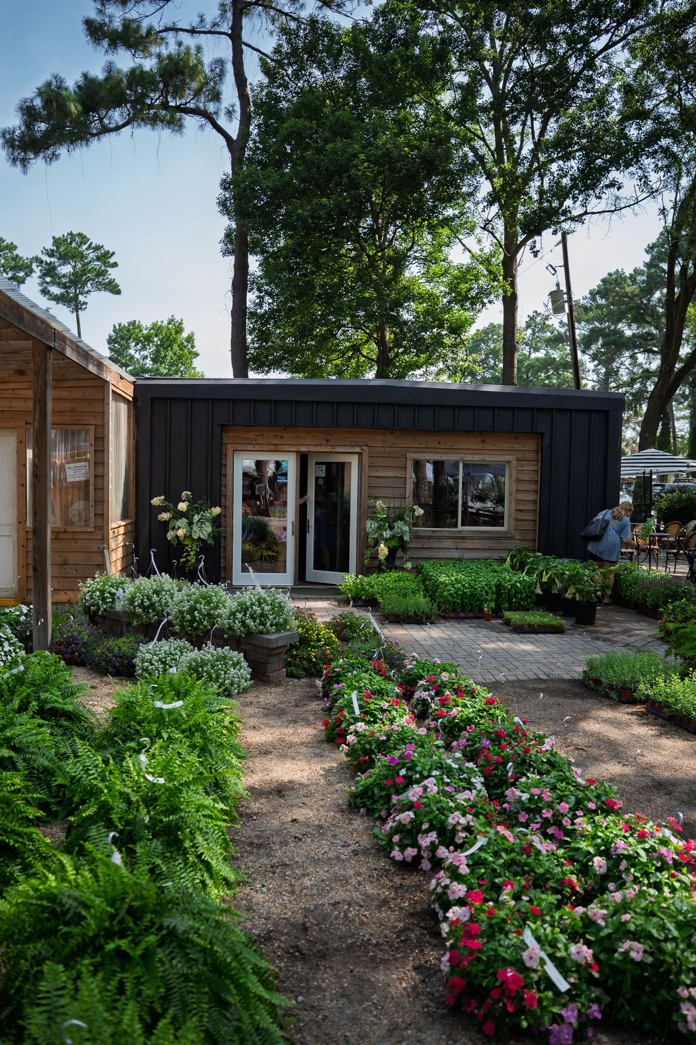 Flower displays and garden plants surround the former Green Thumb nursery building at Bluffton Farm and Flea in Bluffton, South Carolina.