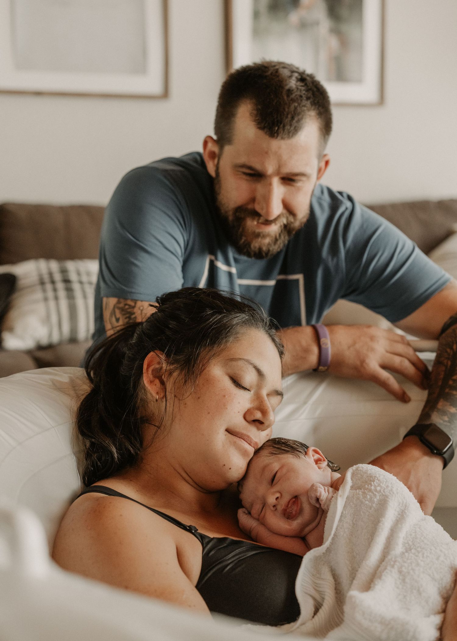 New parents share a tender moment with their newborn baby at home after birth. Anchorage-Birth-Photographer