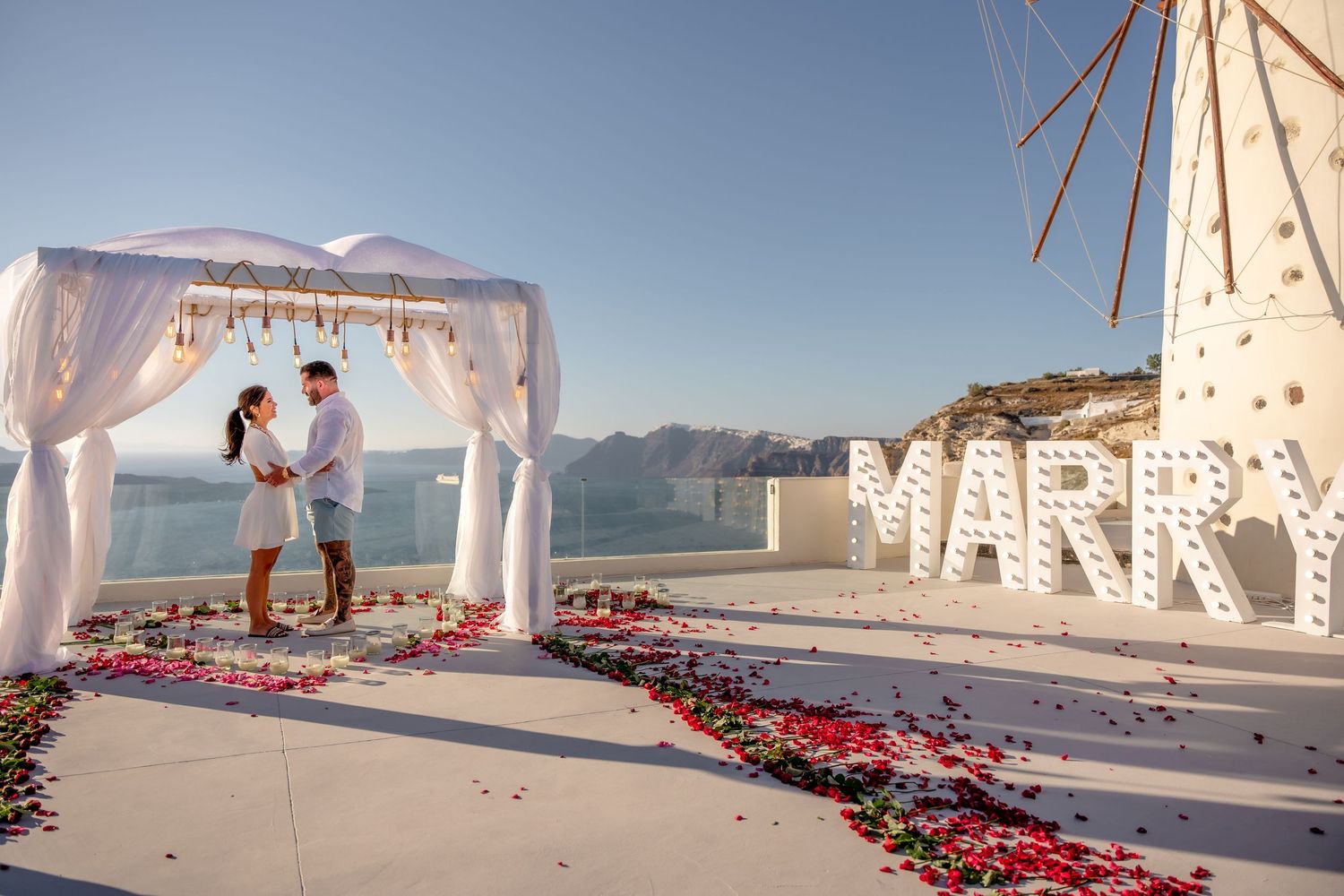 Groom proposing to bride in Santorini with flowers, capturing the magical yes moment