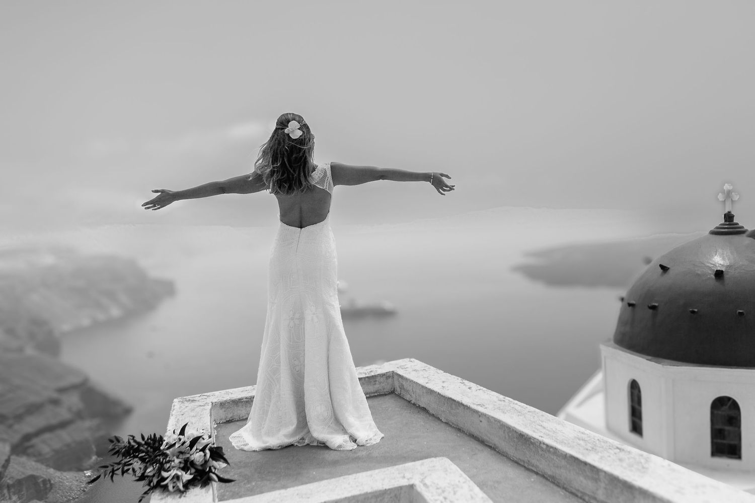 Bride happily ever after at the stunning caldera sea view after an elopement ceremony in Santorini, romantic and natural