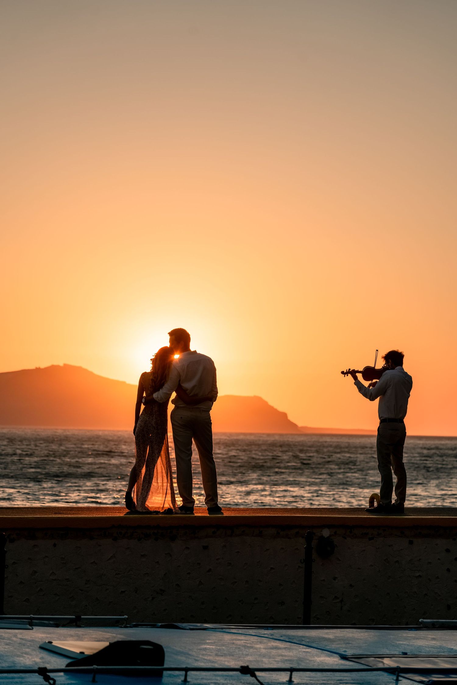 A couple hugging and kissing after a proposal in Santorini at sunset 🌅, capturing love and excitement, romantic and full of emotion.