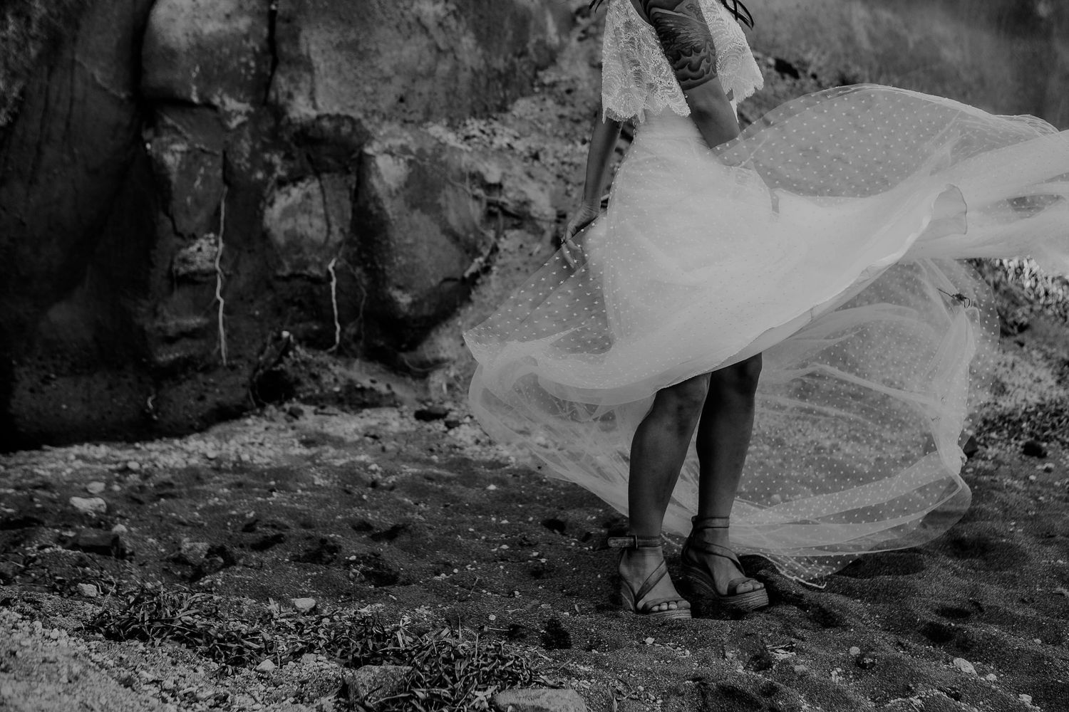 A bride in a wedding dress, during a Santorini day-after session near the sea, natural light highlighting joy and intimacy