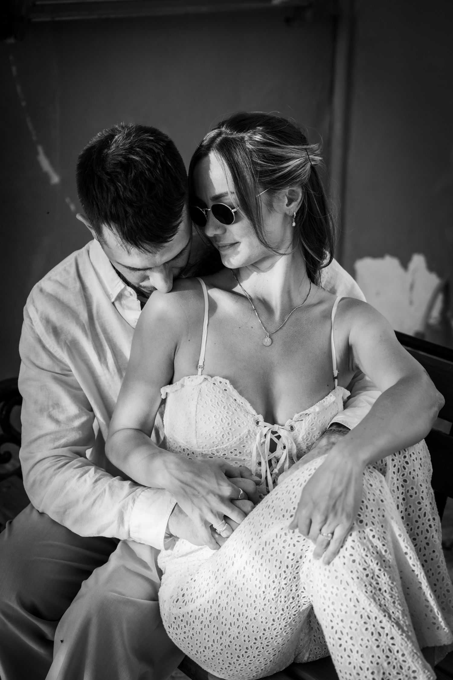 Partners sharing a quiet moment in a Santorini traditional alley, intimate and heartfelt, just after she said, yes. Wedding ring