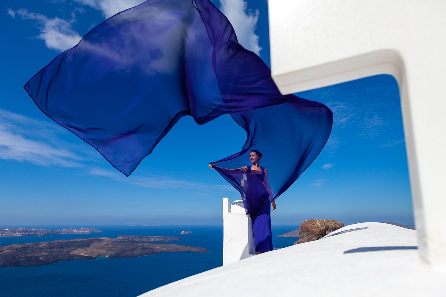 Romantic honeymoon moment captured on a Santorini cliff, on a rooftop, celebrating love and togetherness