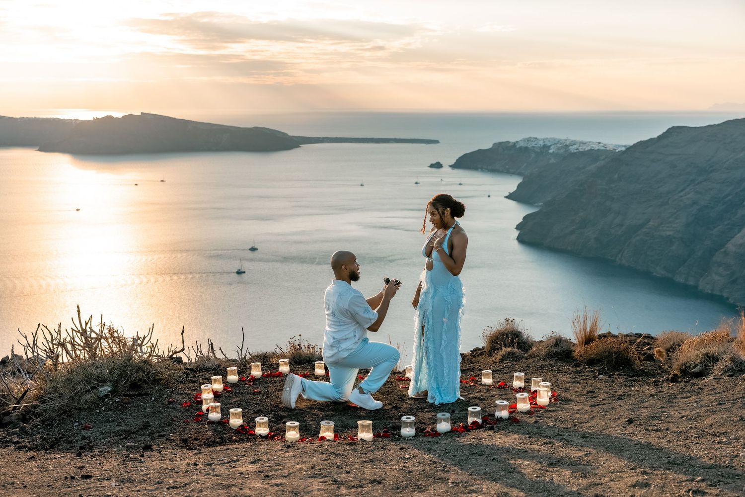 Proposal captured with flowers and rings in Santorini cliffs, intimate and magical