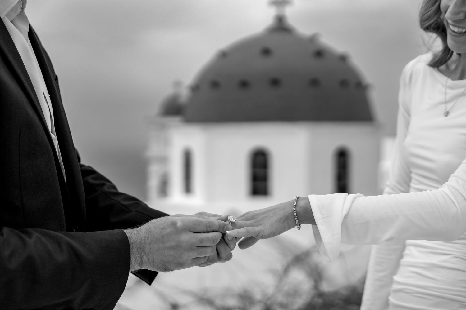 Bride saying yes during an intimate proposal on Santorini cliffs with a blue dome view