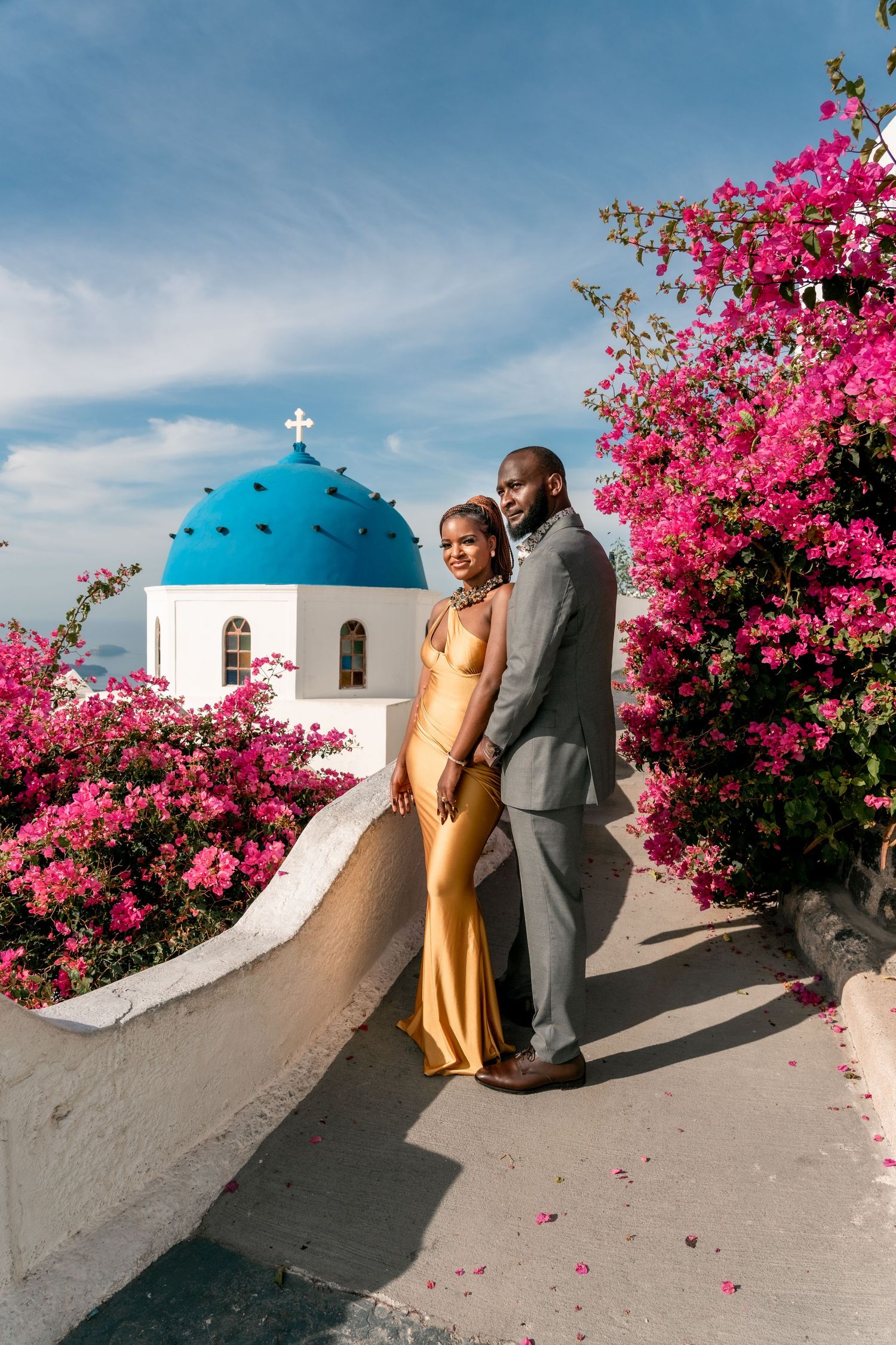 Couple strolling through Santorini’s white streets and blue domes, captured in a joyful lifestyle session