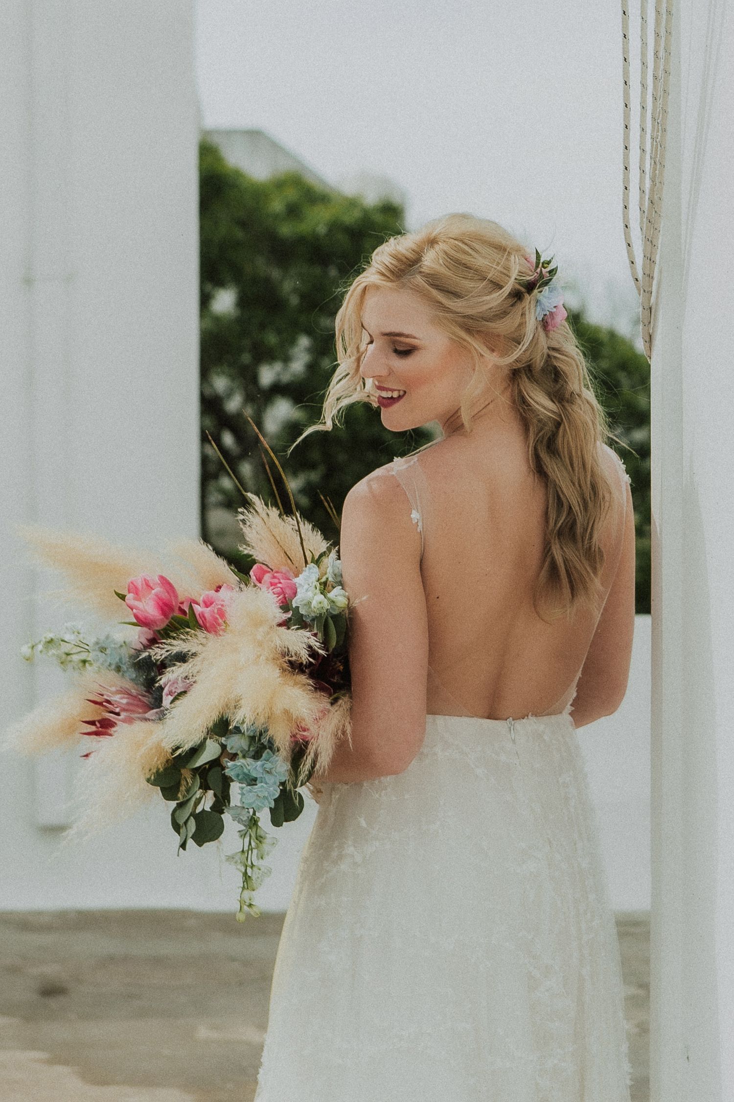 Bride in wedding dress, and wedding bouquet during a Santorini day-after session, capturing authentic connection and happiness.