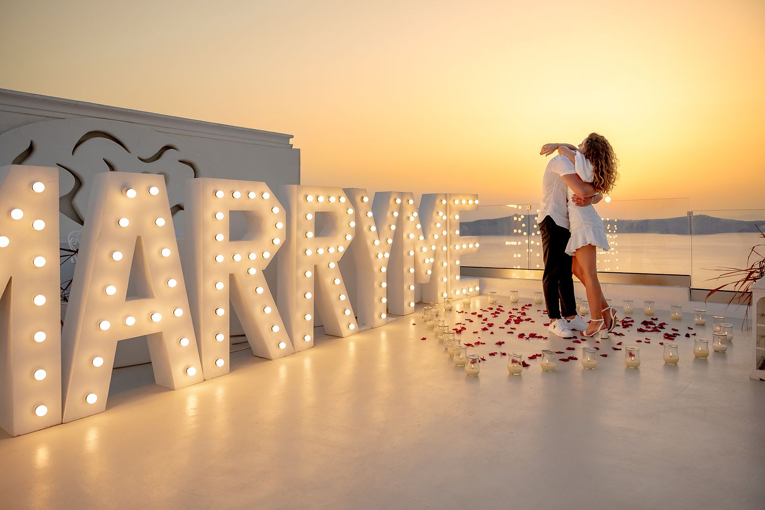 Bride and groom sharing a kiss during a sunset Santorini elopement 🌅 Bride and groom saying yes, surrounded by light and flowers