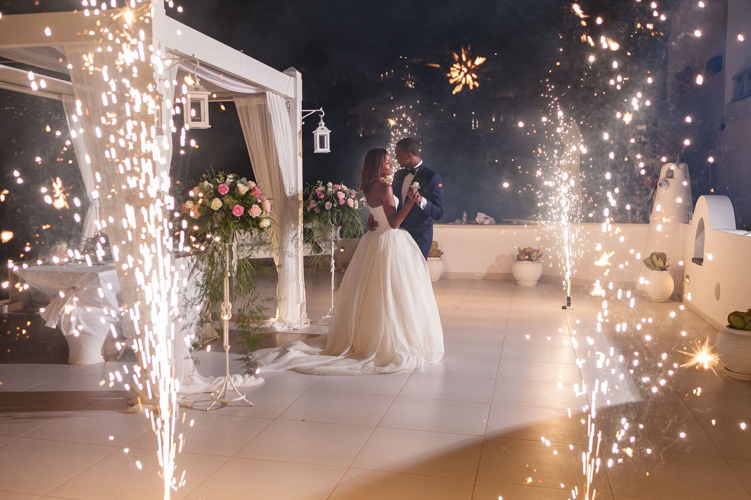 Romantic elopement photoshoot in Santorini, capturing authentic connection and scenery on a terrace, sparkles, love, and laughter in the air