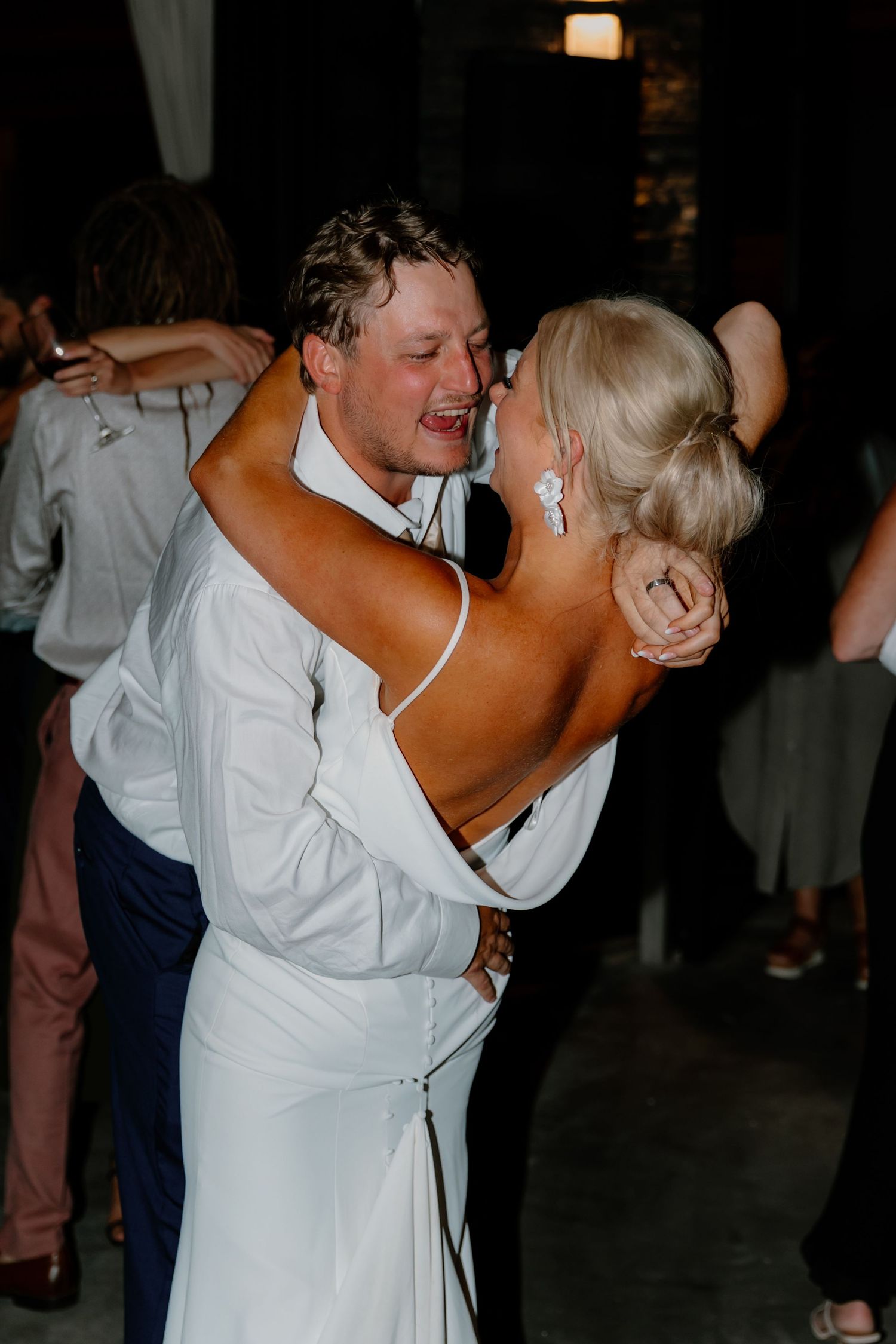 Bride and groom sharing intimate first dance embrace at evening wedding reception.
