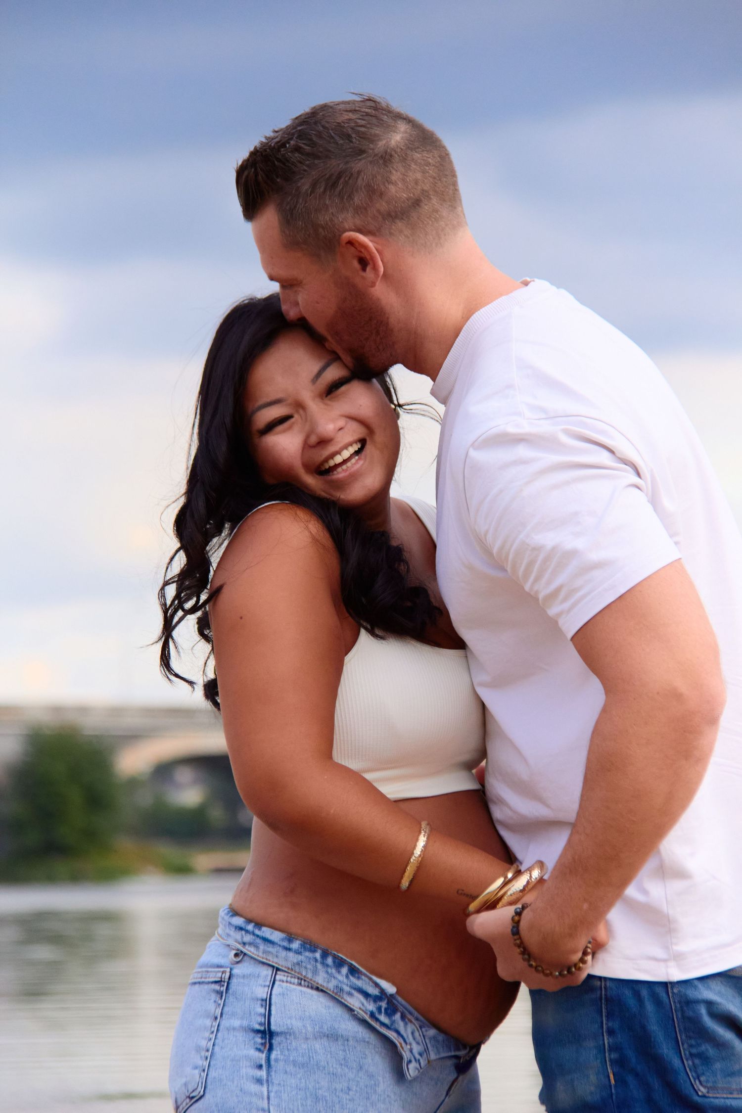 Couple sharing intimate moments and laughter by the water.