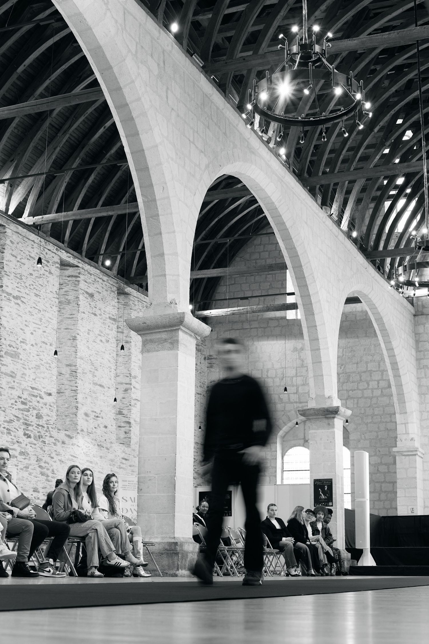 Time-lapse photograph shows movement through an arched stone hallway with dramatic lighting.