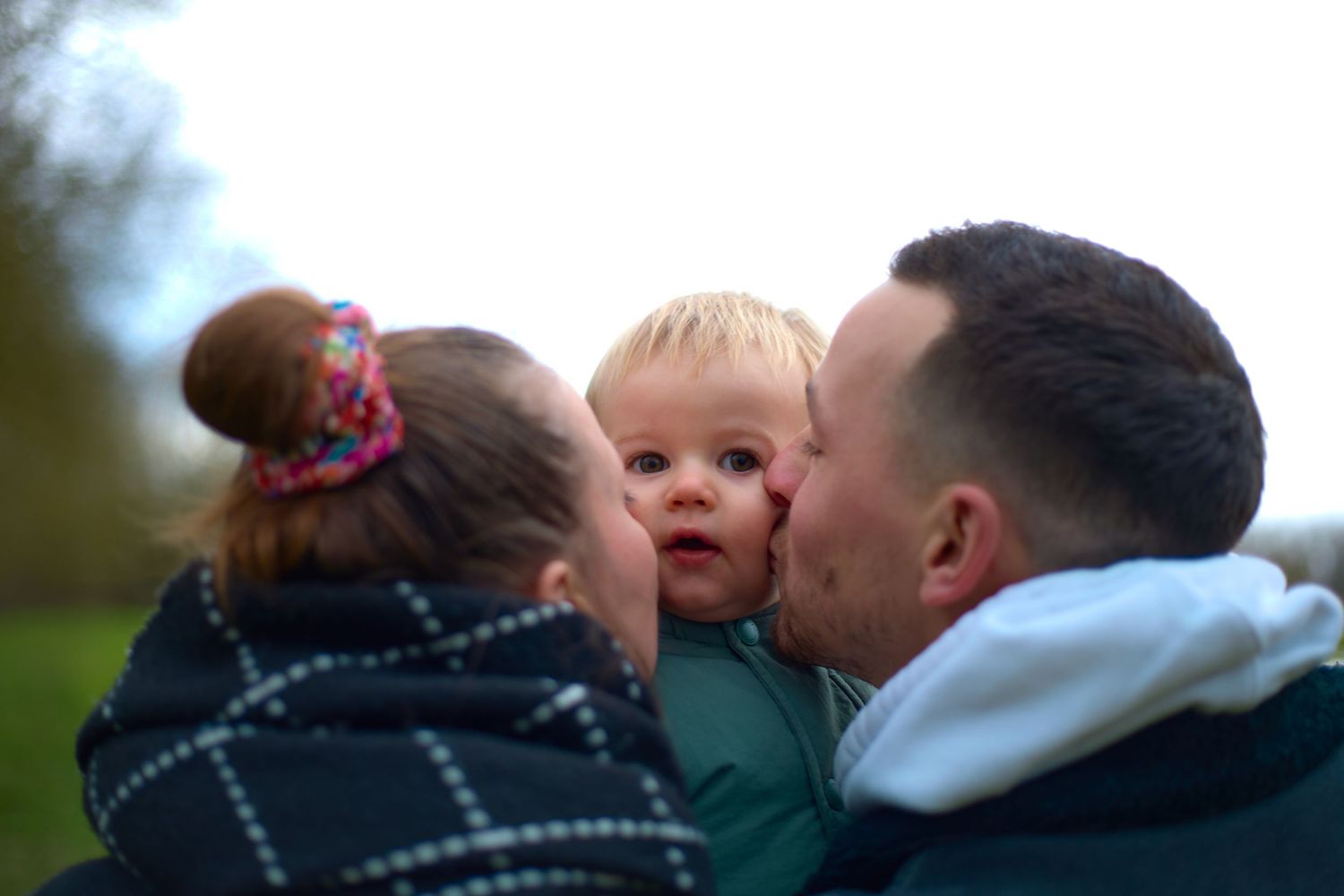 A tender family moment captured during an outdoor photo session at dusk.