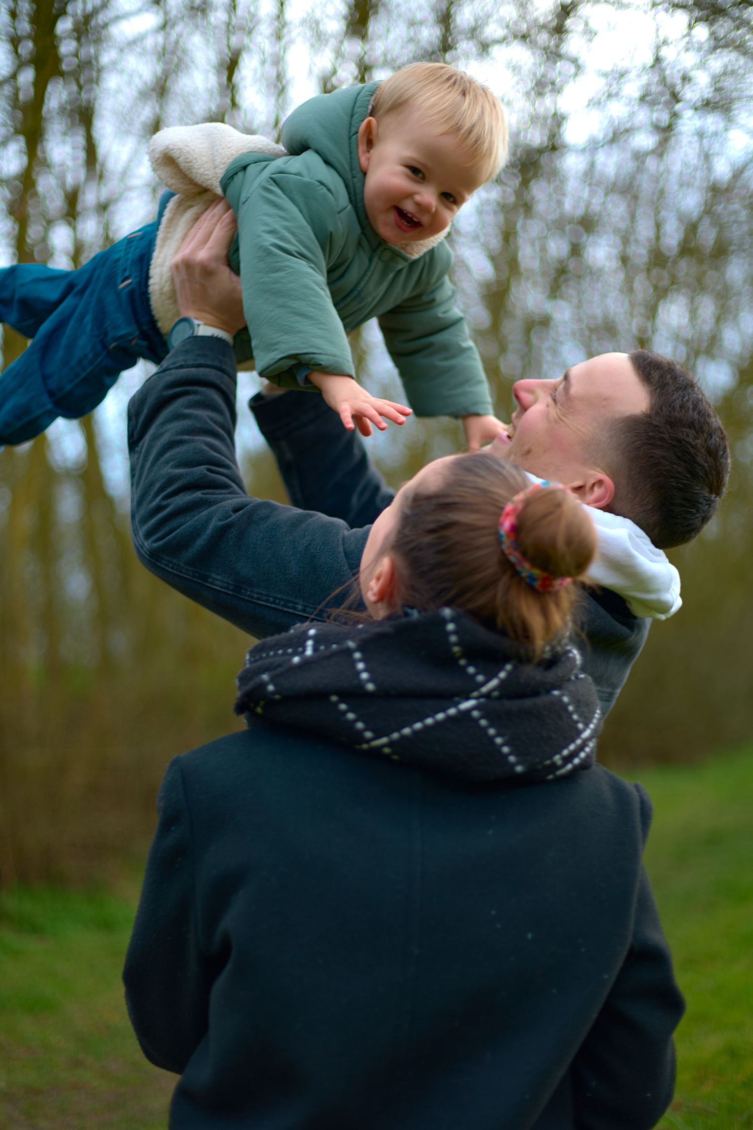 Playful outdoor moment showing joyful interaction and lifting in a natural setting.