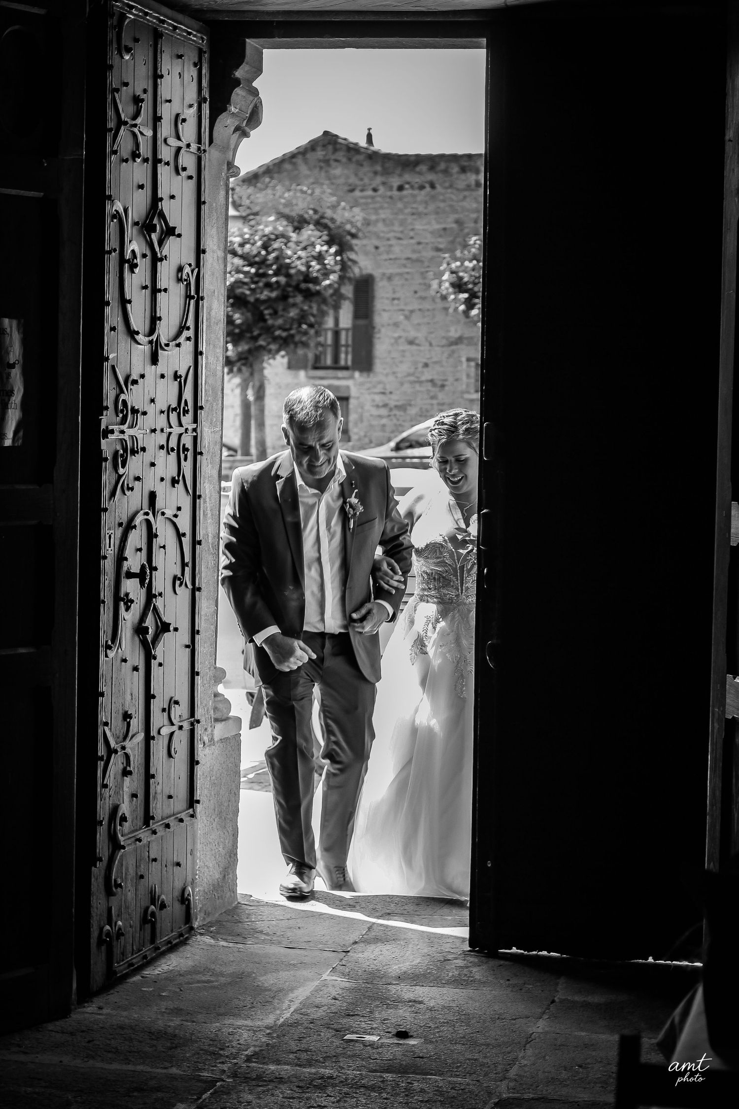 Silhouetted figures enter through a doorway in dramatic black and white composition.