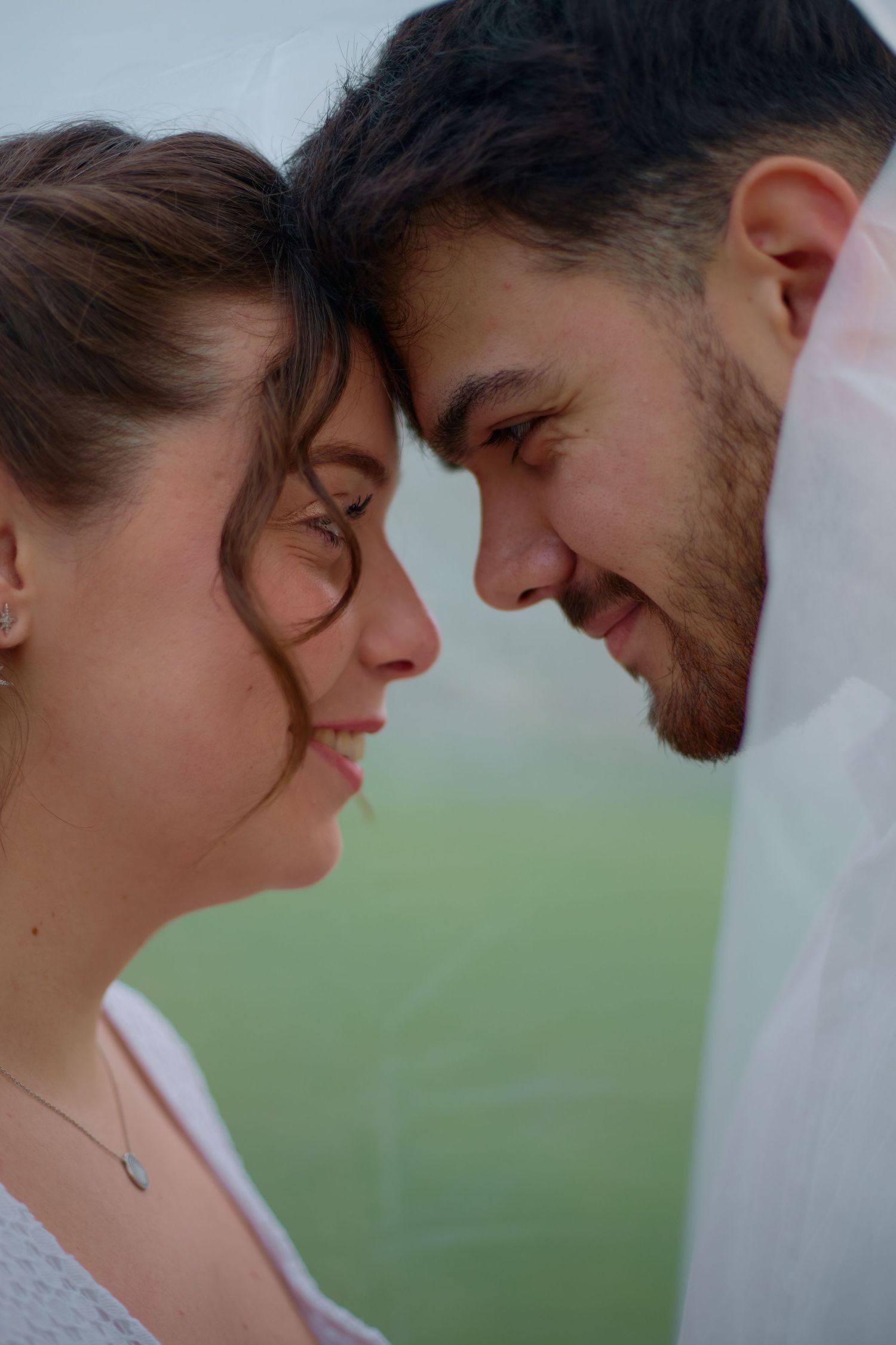 A close-up intimate moment between a couple sharing a tender smile.