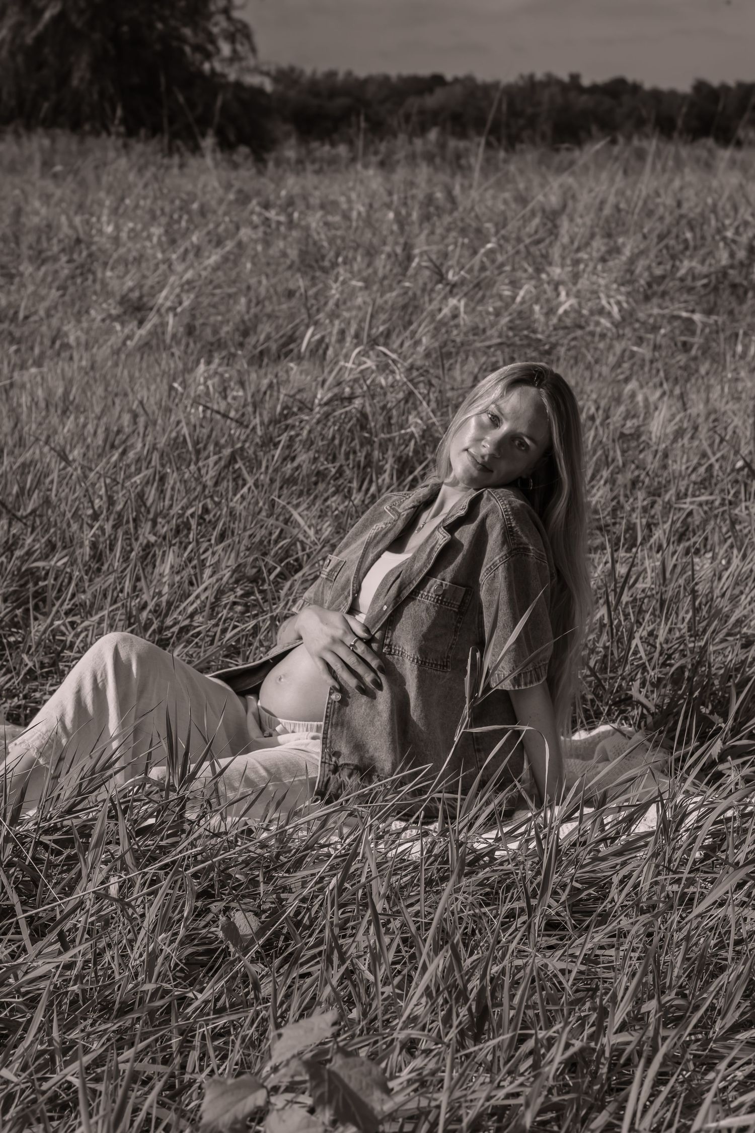 A series of black and white photographs showing someone lying peacefully in tall grass meadow.