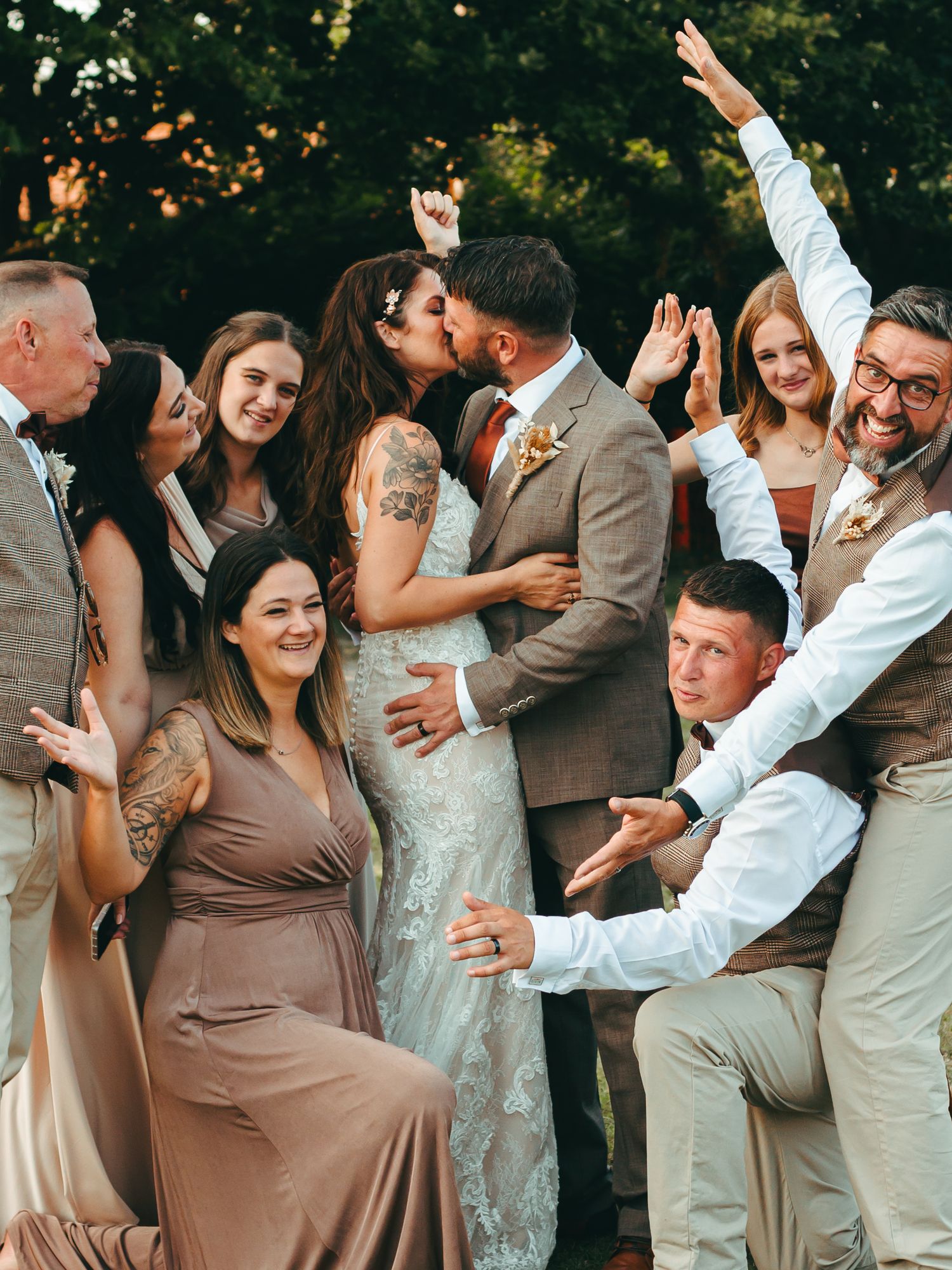 Wedding party celebrates as the couple embrace.