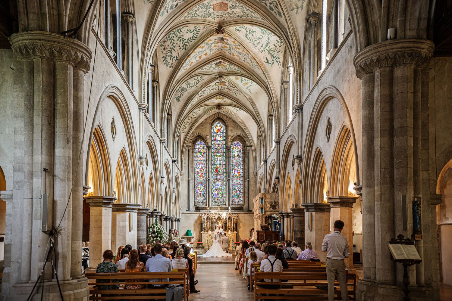 The Panoramic view of the Gothic cathedral interior of Boxgrove Priory Church with vaulted ceilings, stone columns and arched walkways.