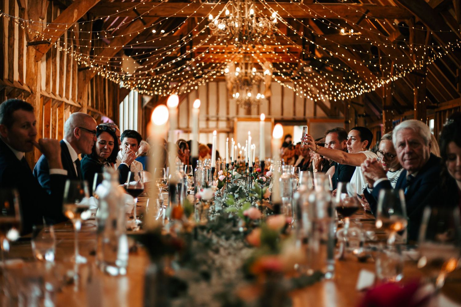 Elegant wedding reception with glowing chandeliers and string lights creating a warm, romantic atmosphere at Southend Barns near Chichester.