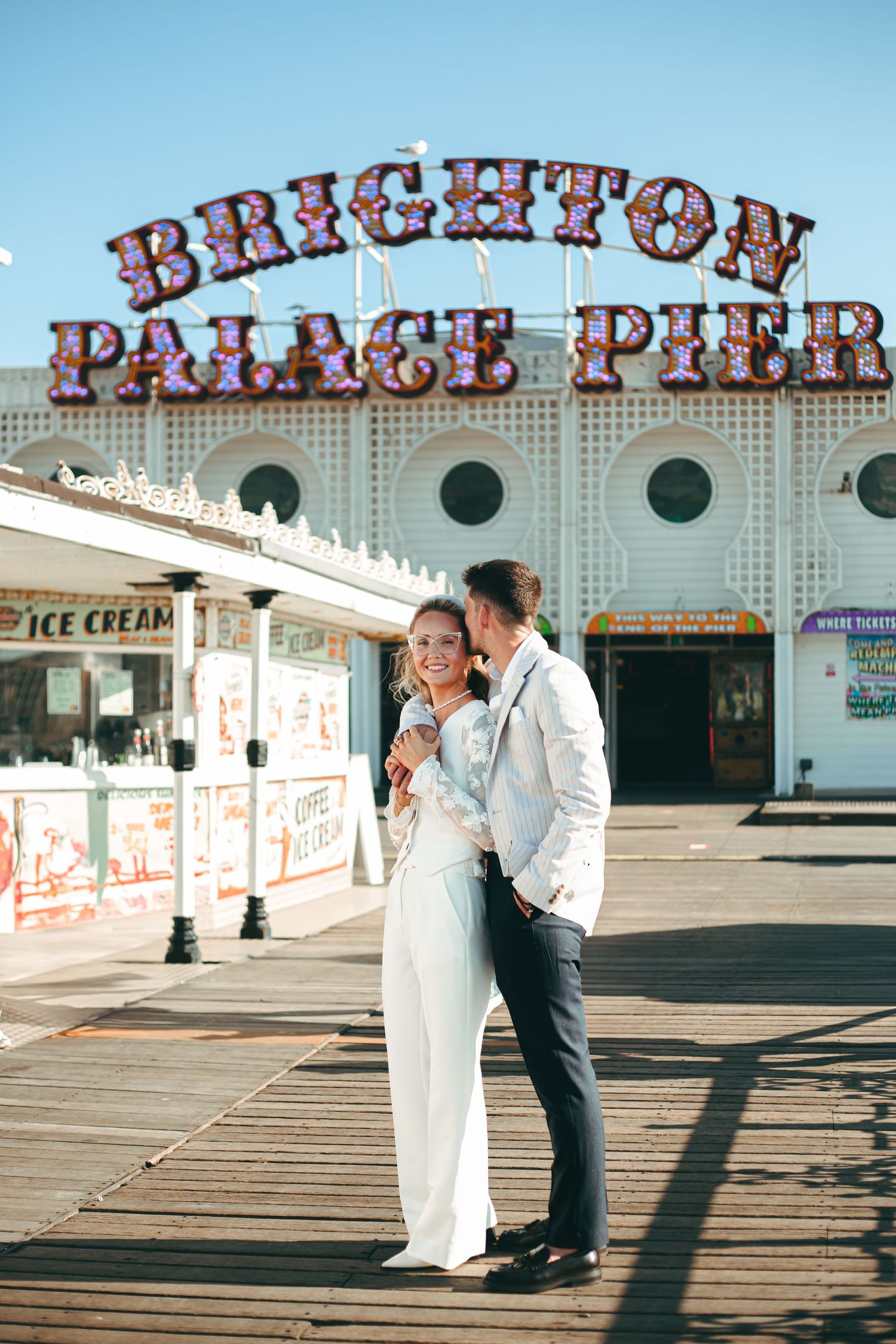 Wedding couple relaxed candid portraits in front of Brighton Palace Pier on a sunny day.